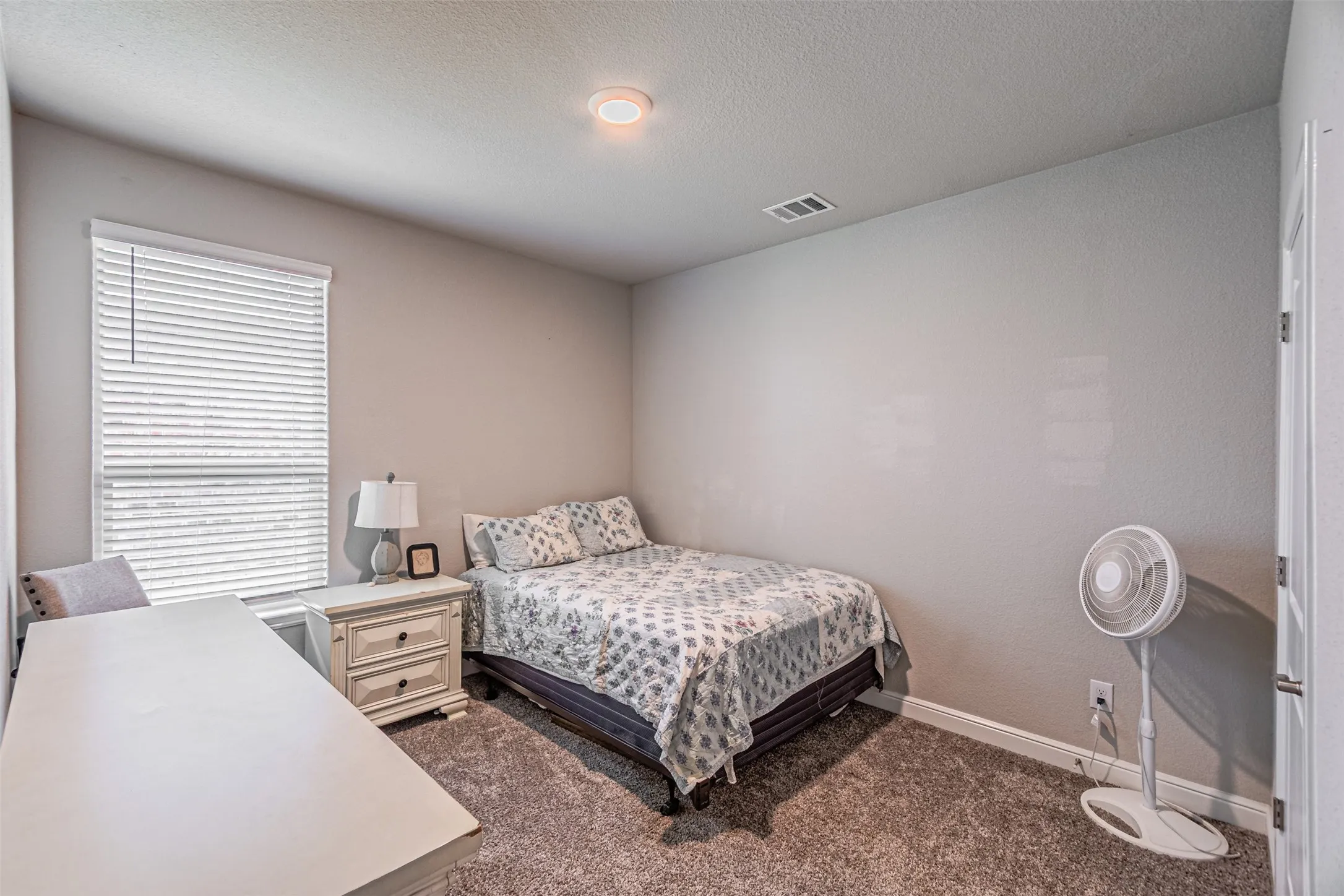 Recessed ceiling lighting, textured wall finish, window with horizontal blinds, and carpeting