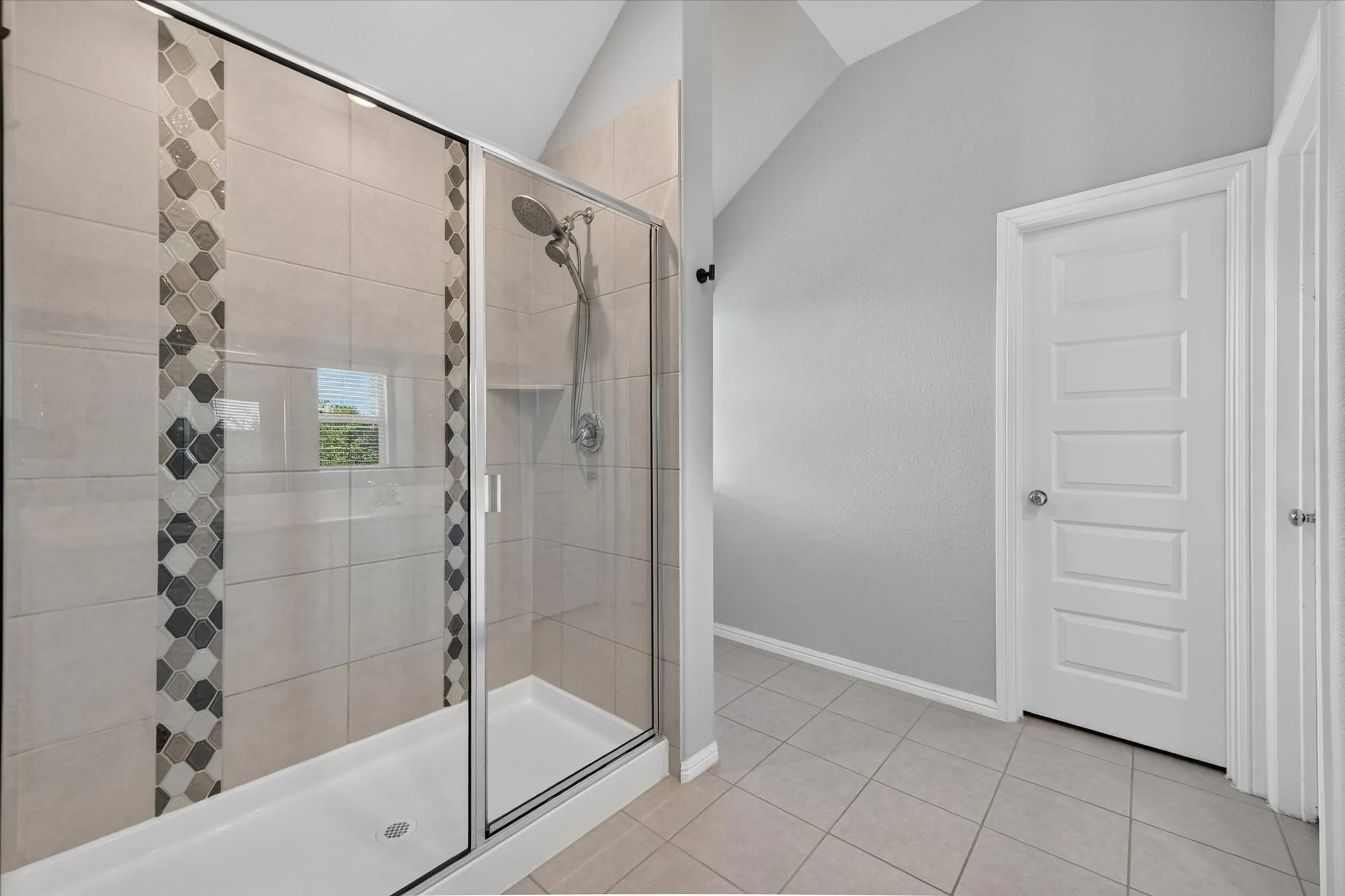 Spacious room featuring two windows with horizontal blinds, neutral wall tones, textured carpeting, and a white paneled door