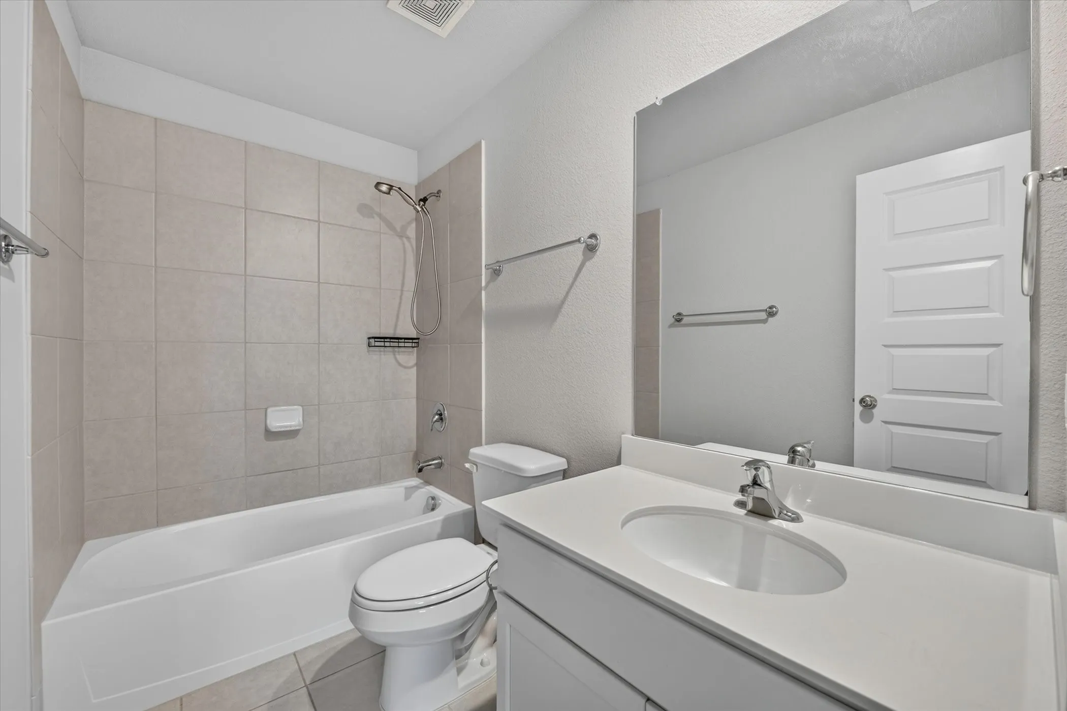 Glass-enclosed shower with a tiled surround, decorative mosaic tile accents, and a built-in shower niche