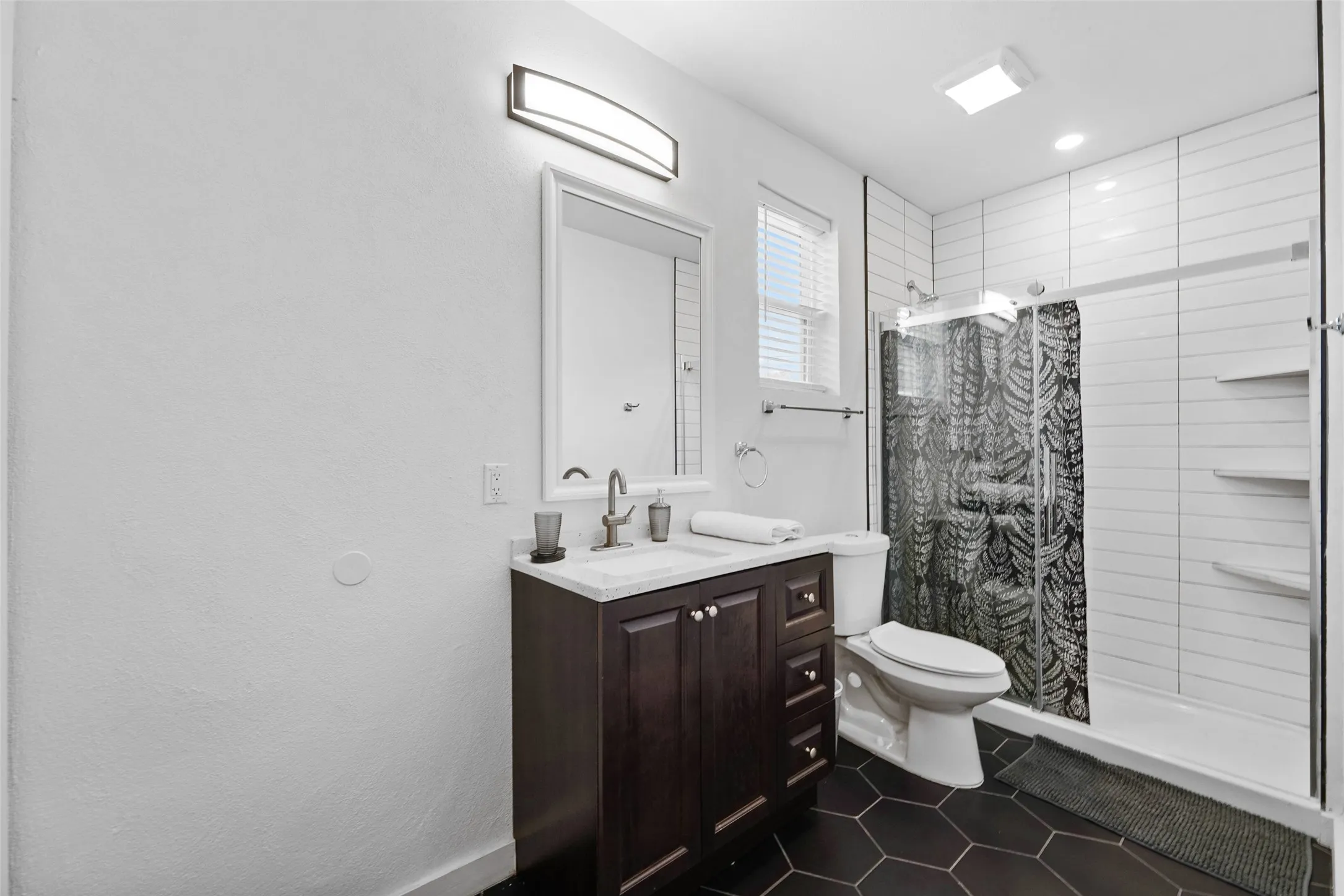 Dark wood-finish vanity with a white countertop and rectangular sink