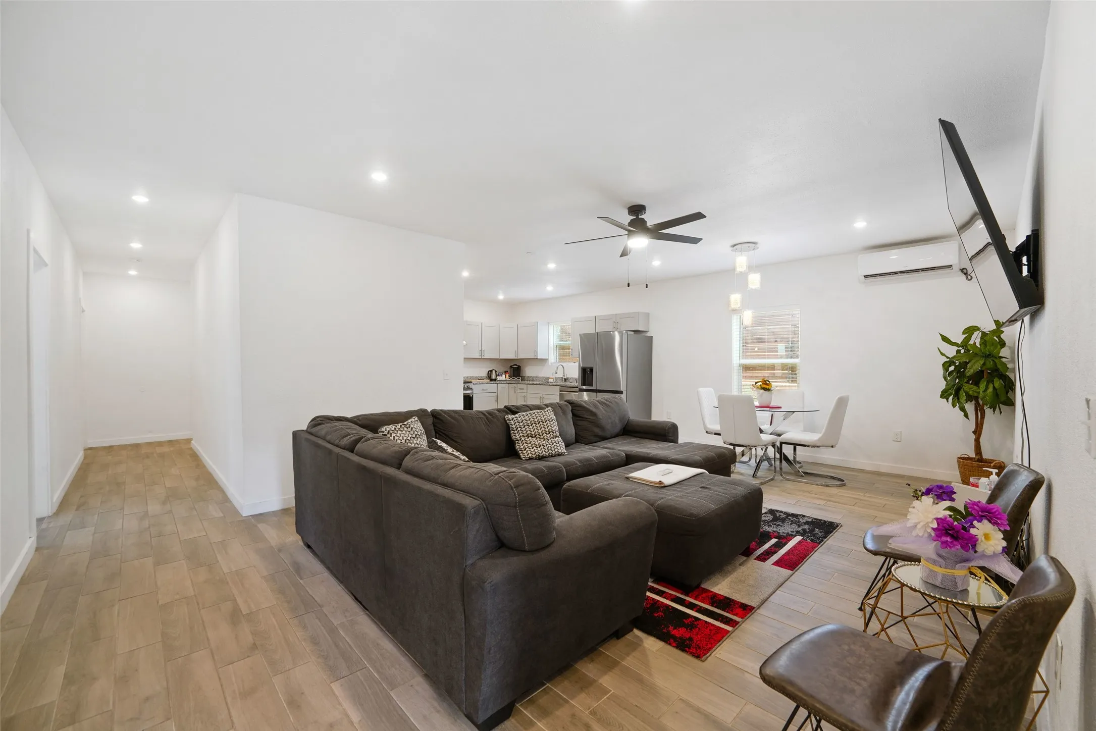 Open-concept living area featuring wood-finish flooring, recessed lighting, and a ceiling fan