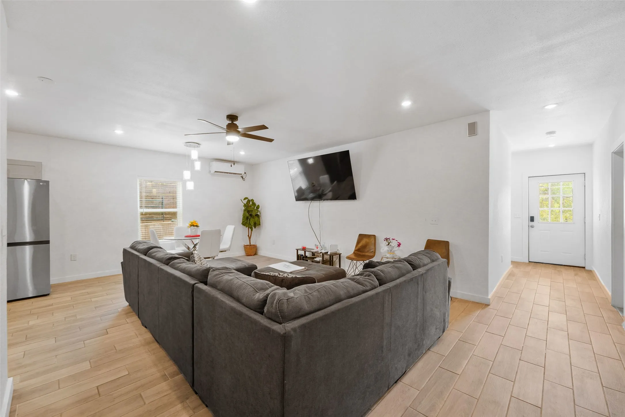 Open-concept living space featuring wood-finish flooring, recessed lighting, and a ceiling fan
