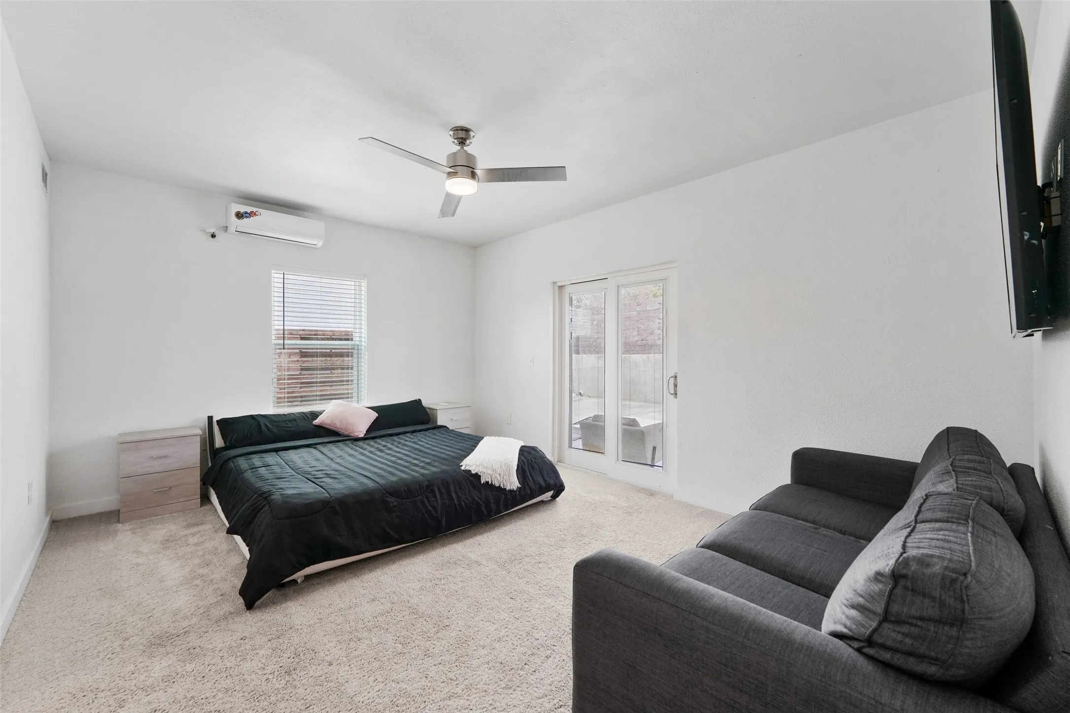 Carpeted flooring with white walls and a ceiling fan