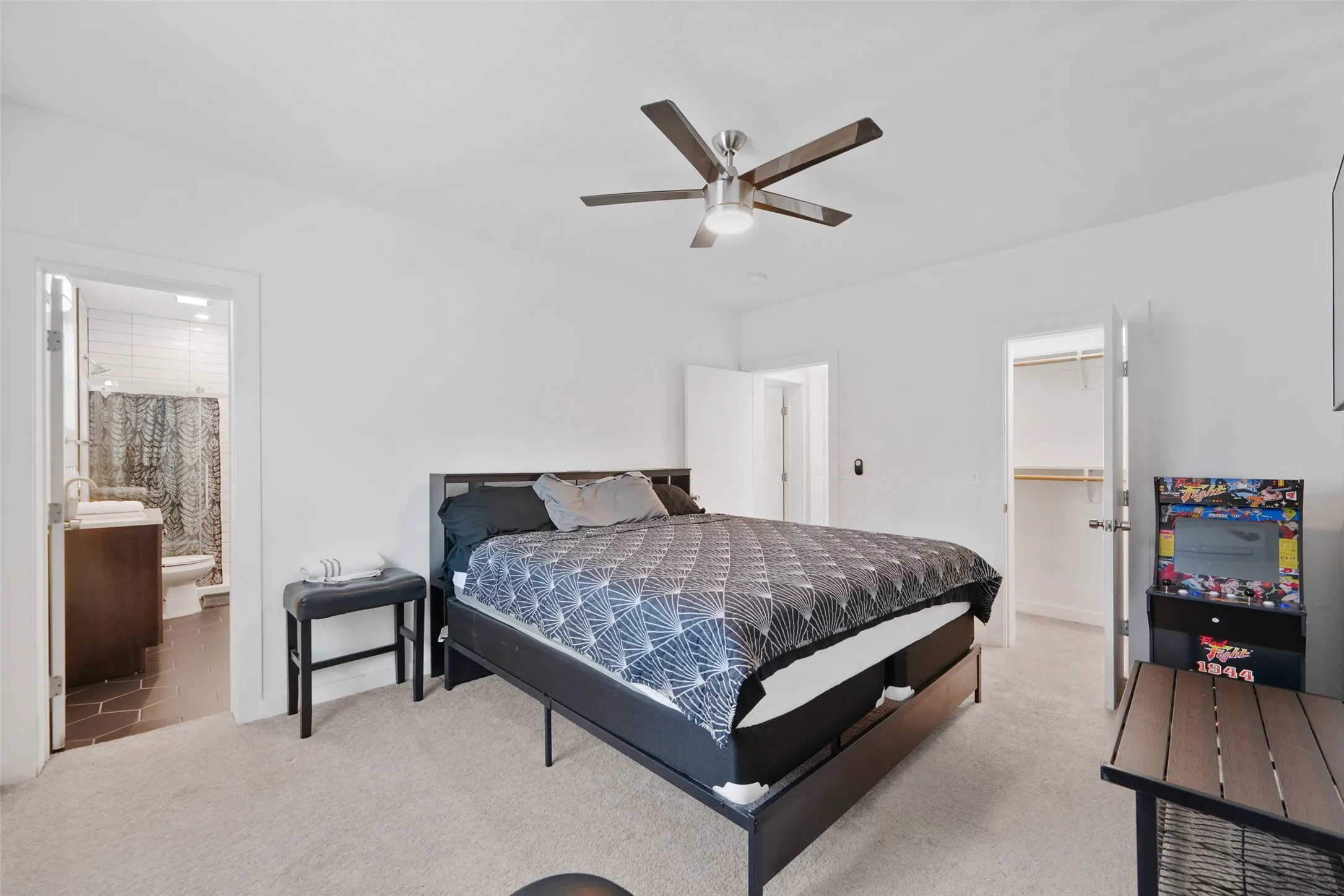 Neutral tone wall finishes, carpeting, and a ceiling fan with integrated lighting