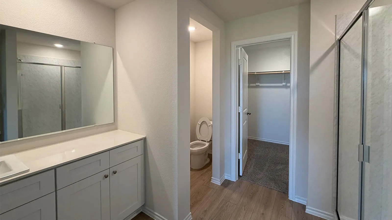 Bathroom vanity featuring light-colored cabinetry, a rectangular undermount sink, and a large wall-mounted mirror