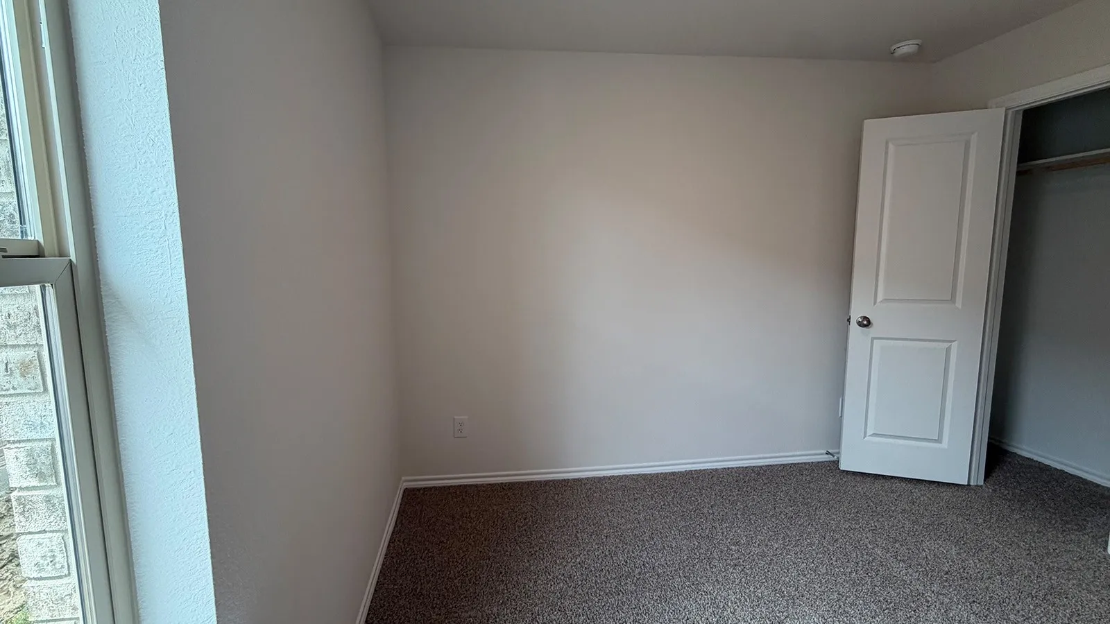 Recessed lighting illuminates neutral carpeting and light-colored walls