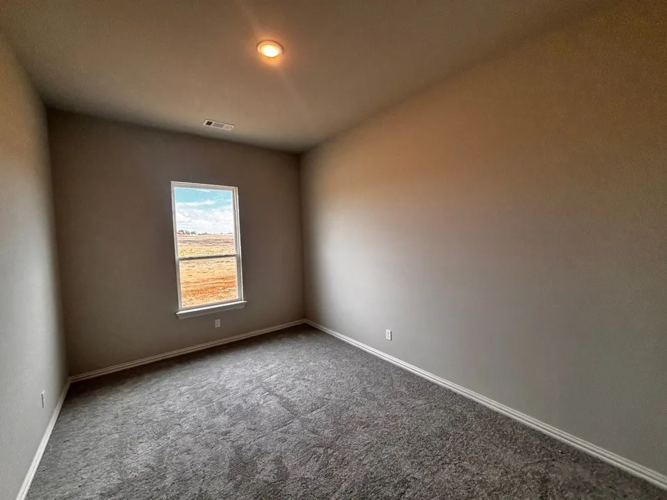 Recessed ceiling light, neutral wall paint, single window, gray carpeting, and white trim
