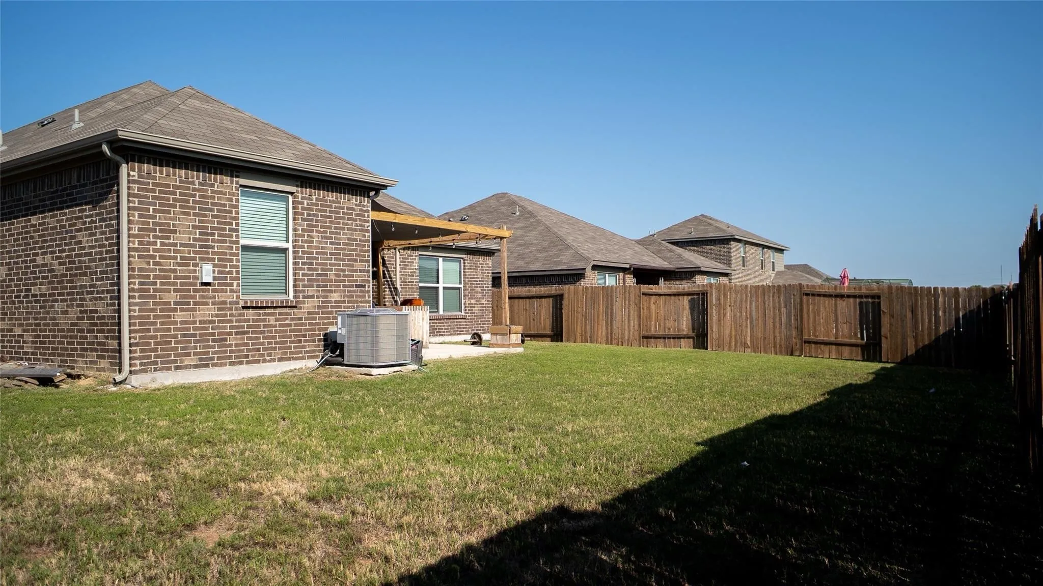 Expansive grassy lawn with a full privacy fence