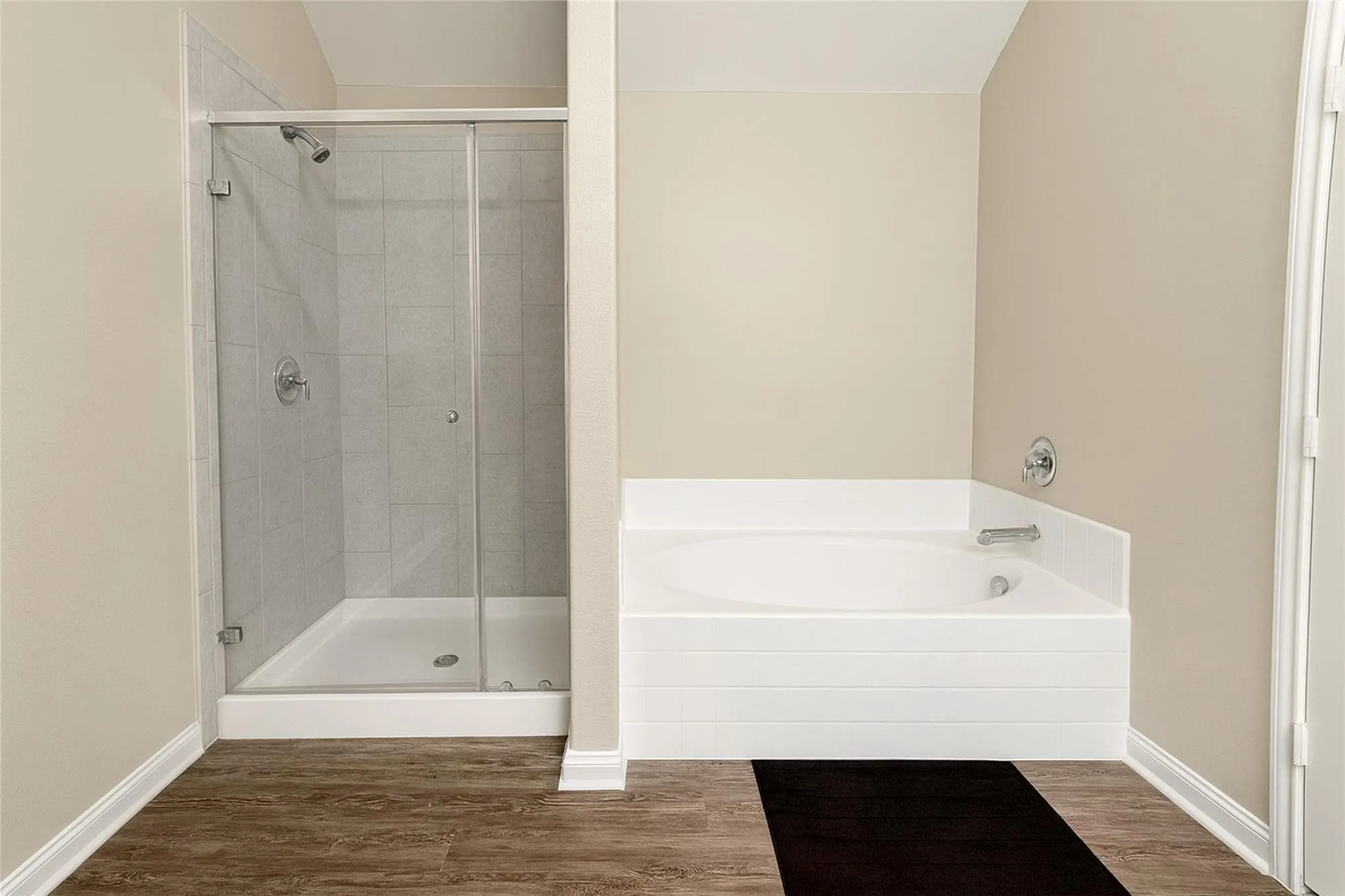 Walk-in shower with clear glass enclosure, tiled walls, and chrome fixtures