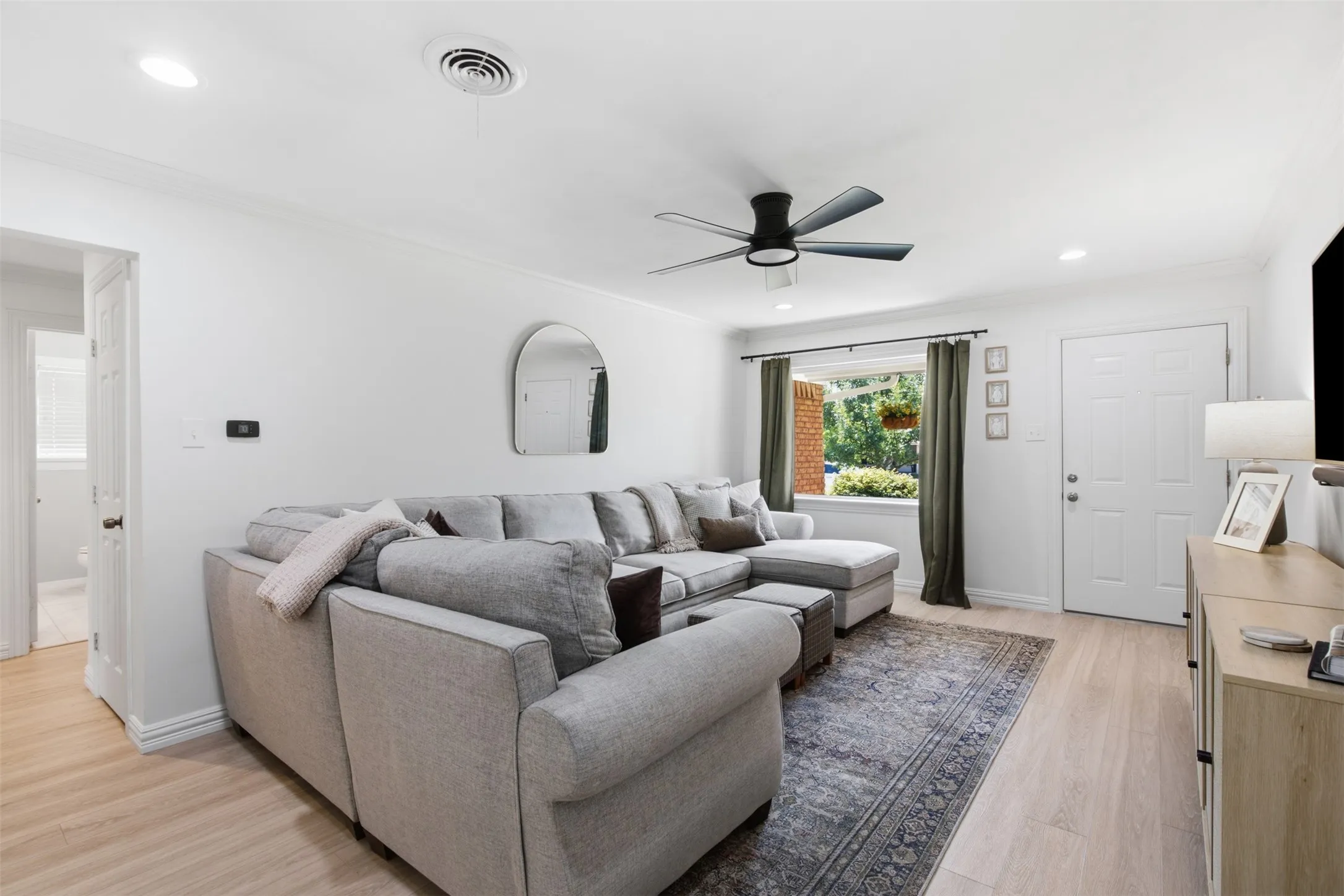Recessed lighting, wood-finish flooring, white walls, ceiling fan, and white paneled door