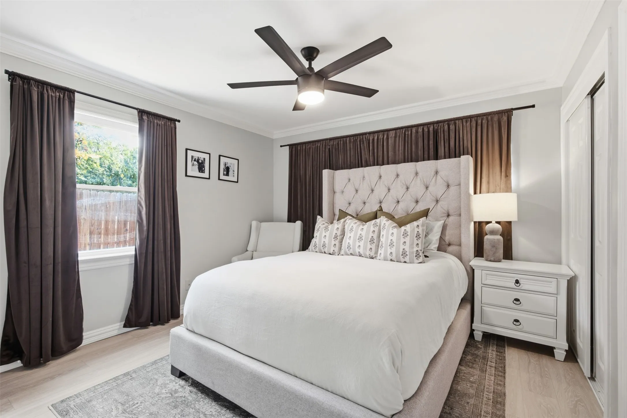 Crown molding, a ceiling fan with integrated lighting, wood-finish flooring, and a built-in closet with bi-fold doors