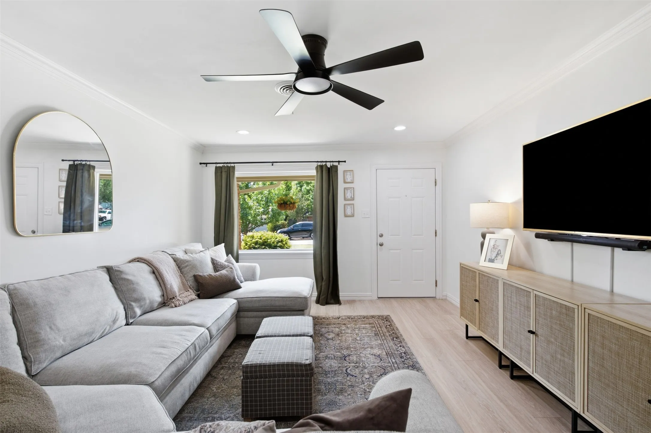 Recessed lighting, crown molding, a modern ceiling fan, wood-finish flooring, and a paneled entry door