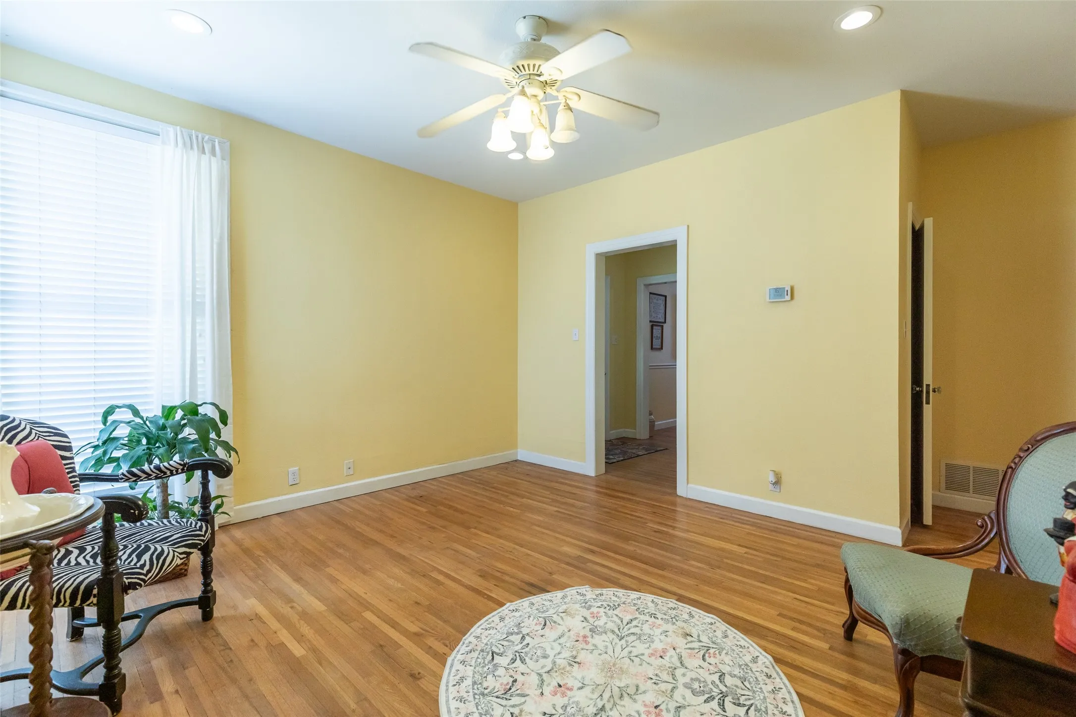 Hardwood flooring, recessed lighting, ceiling fan, white window blinds, and white trim