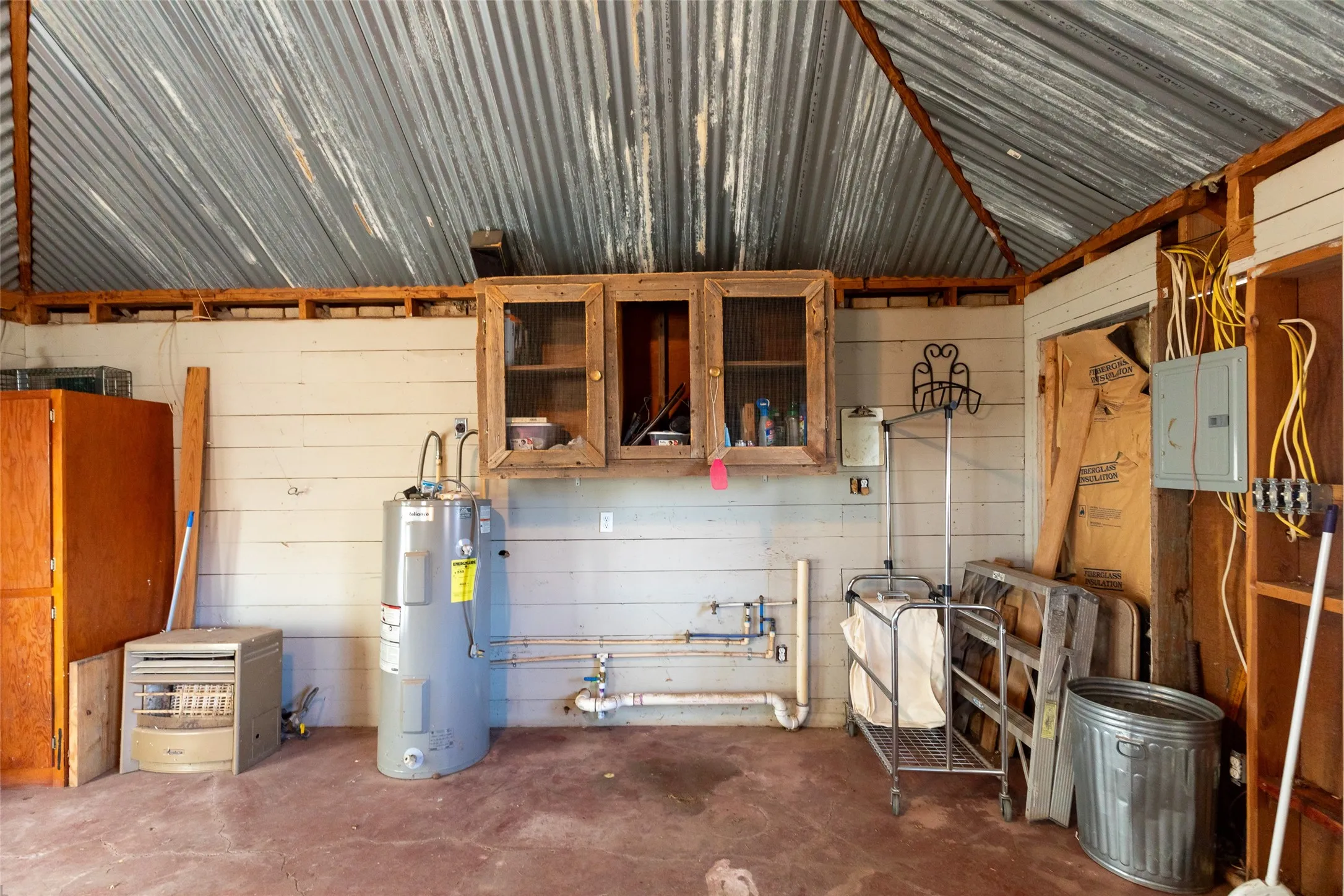 Corrugated metal vaulted ceiling with exposed wood beams, dual pane windows, and a ceiling fan with integrated lighting