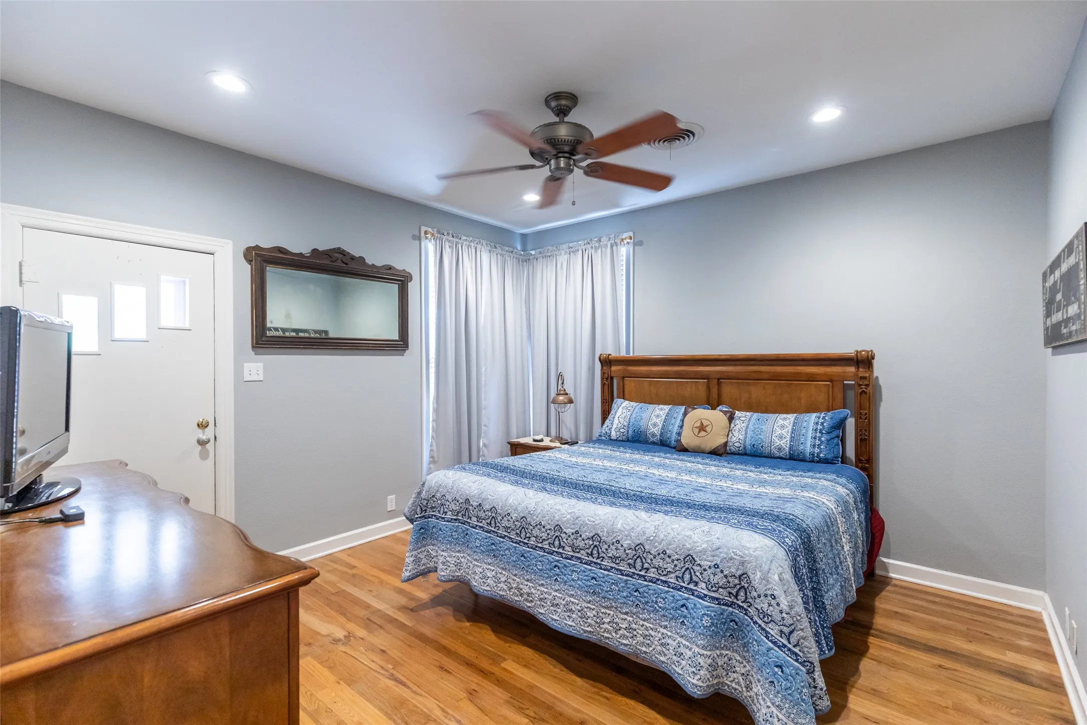 Wood-finish flooring, recessed lighting, and a ceiling fan with integrated lighting