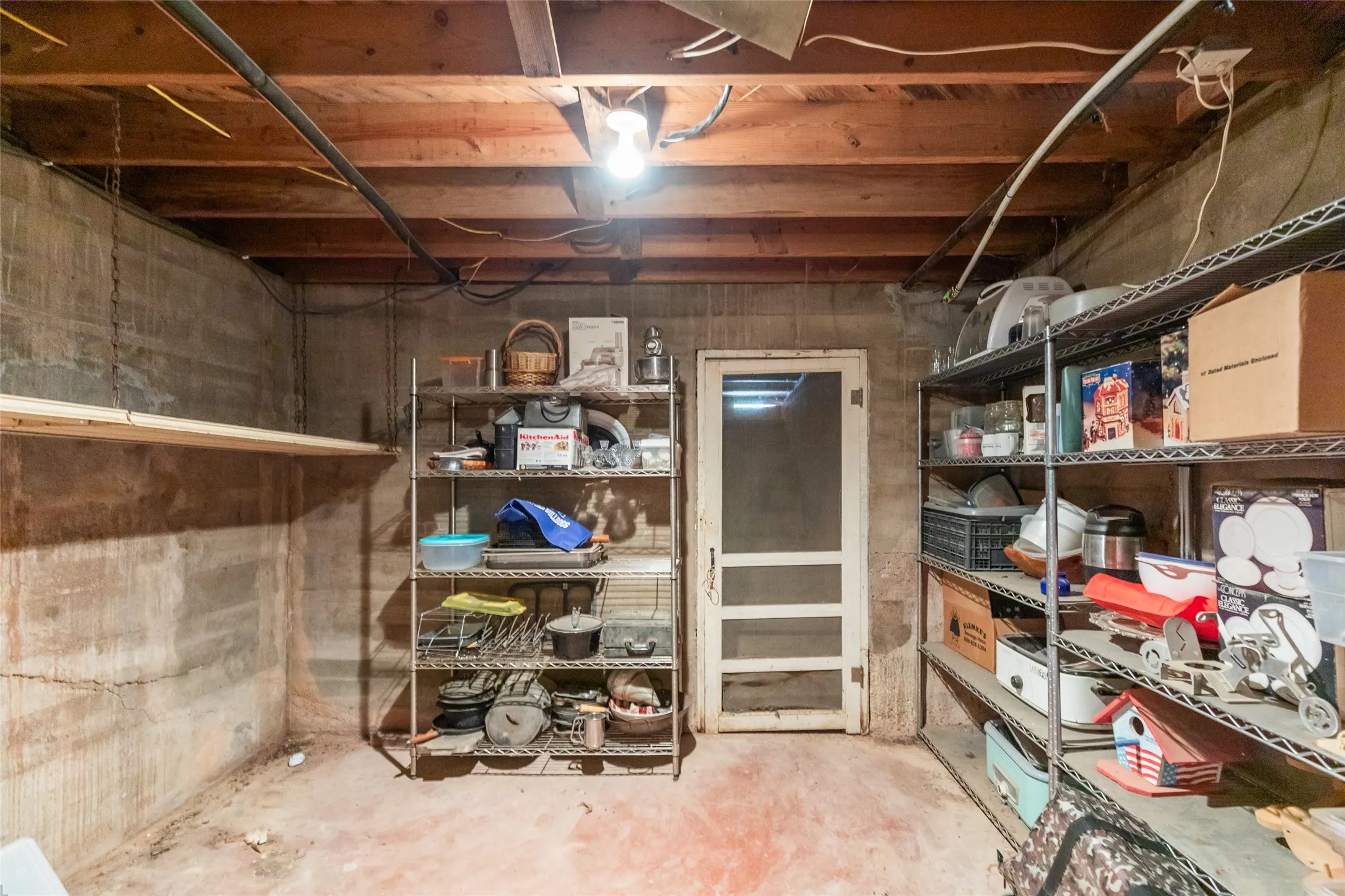 Unfinished interior space featuring exposed wood joists and concrete walls