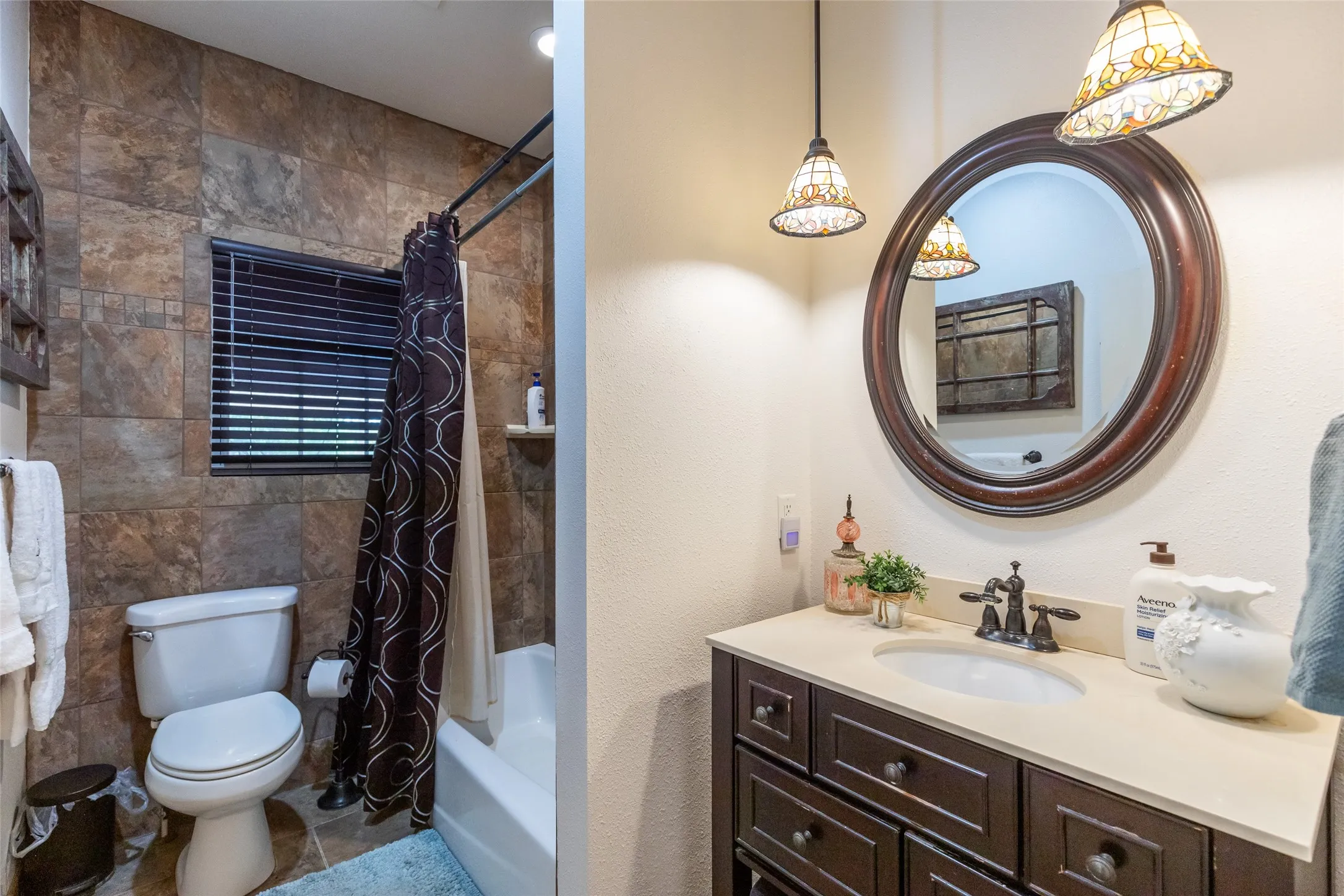 Vanity with a light-toned countertop, undermount sink, and dark wood-finish cabinetry