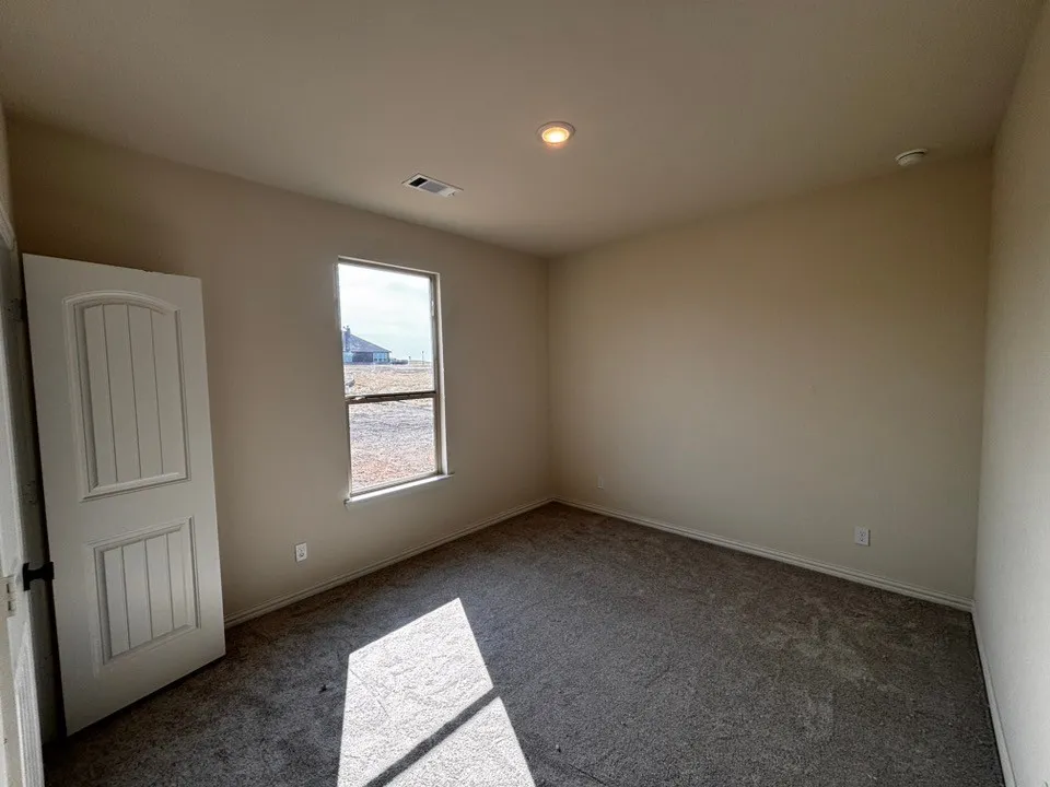 Neutral wall paint, recessed ceiling lighting, and grey carpet flooring
