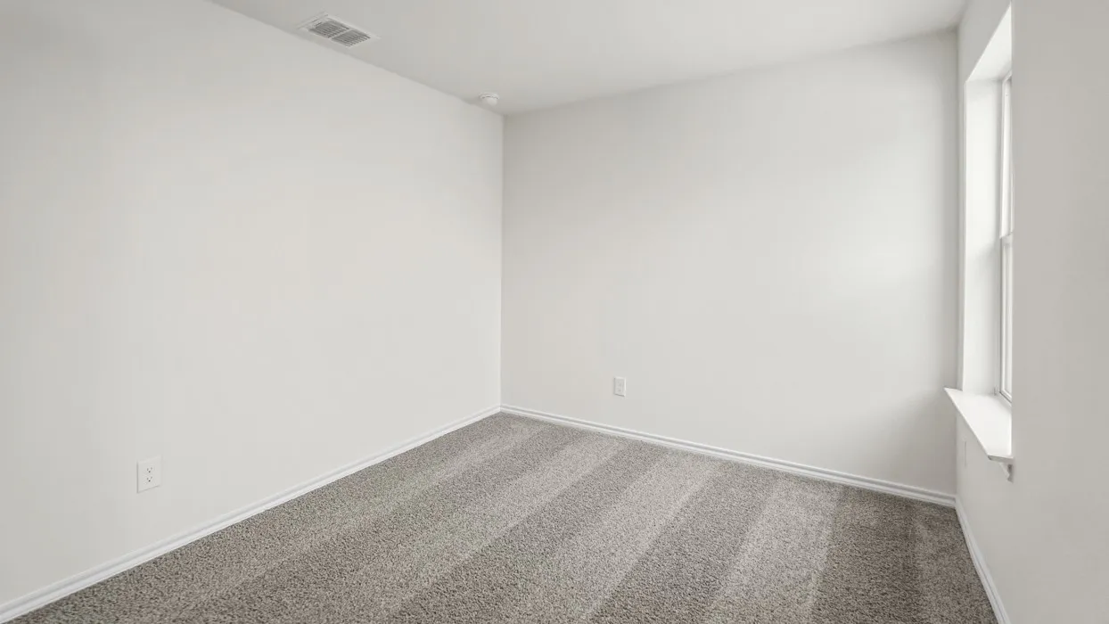 Neutral-toned wall-to-wall carpeting with a window providing natural light