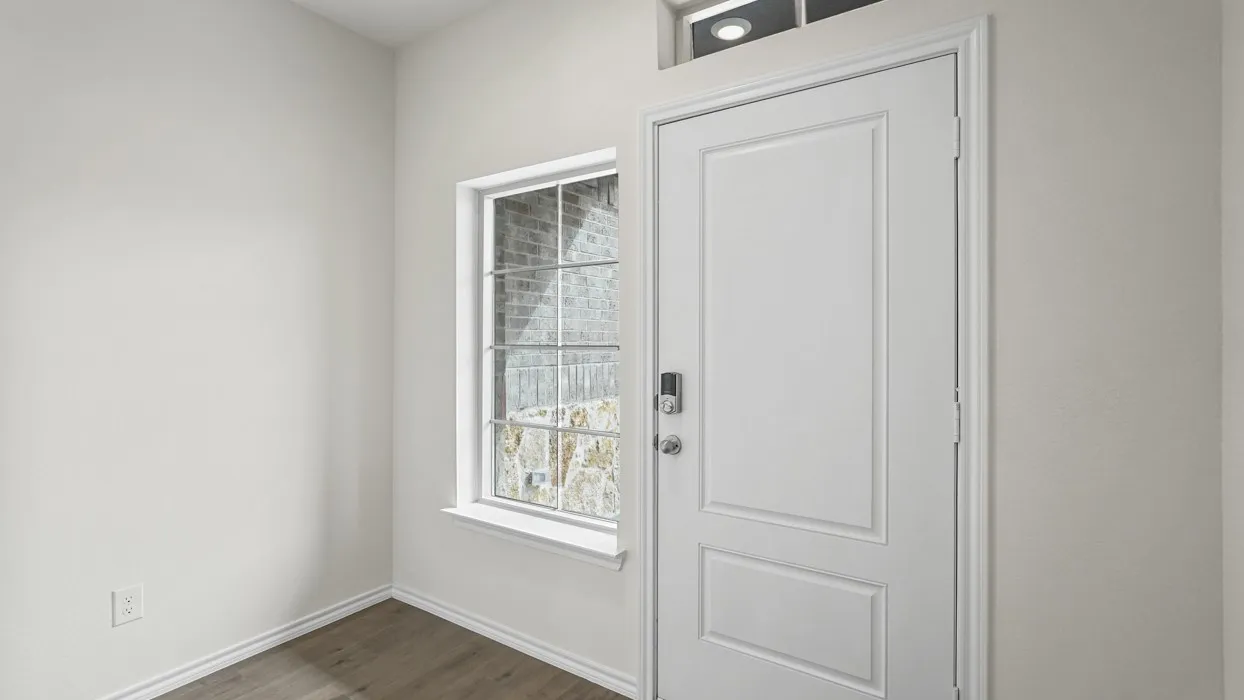 Entryway featuring a paneled door with smart lock hardware, a transom window, and wood-finish flooring