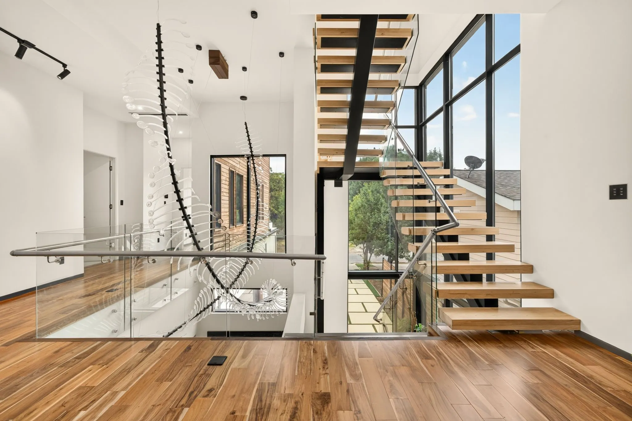 Floating wood-finish staircase with glass and stainless steel railing