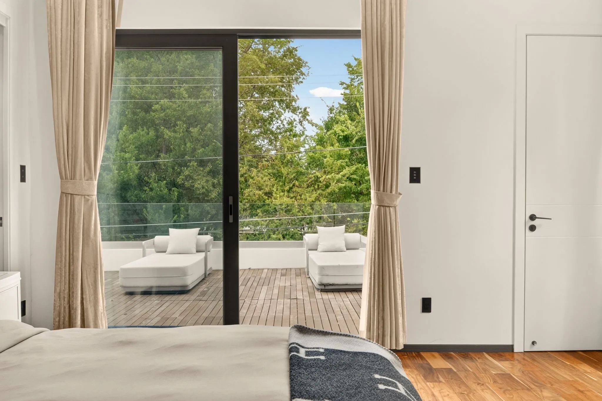 Hardwood flooring, sliding glass door, private balcony, glass balcony railing, white interior door