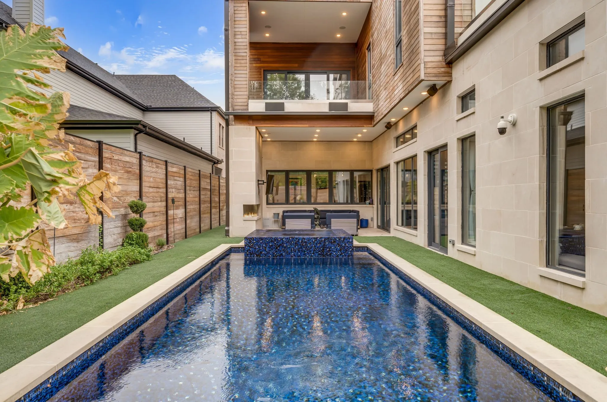 Outdoor lap pool with integrated spa and stone coping
