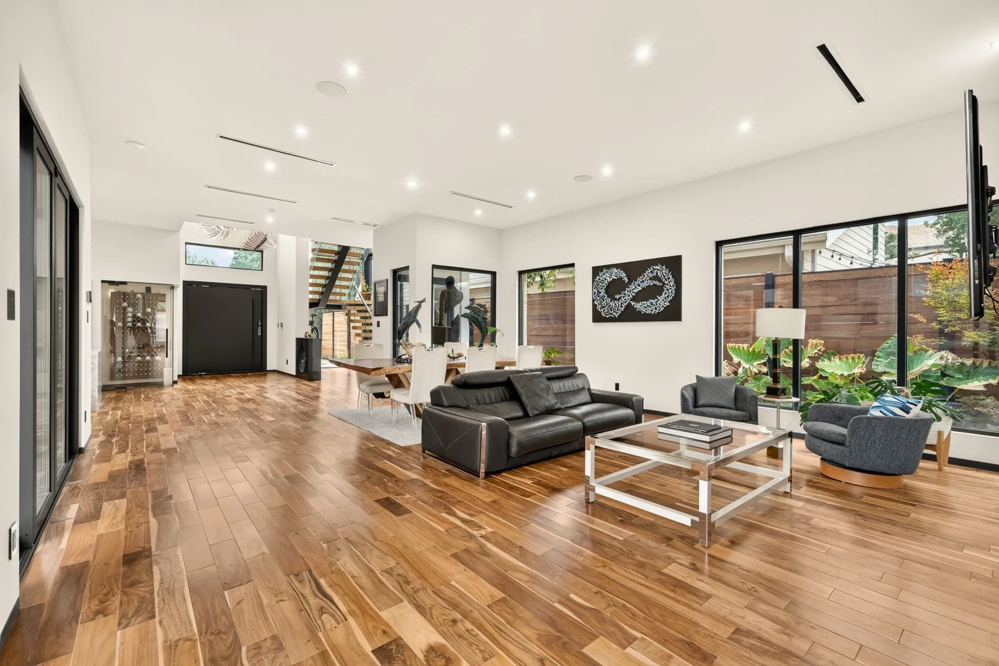 Hardwood flooring, recessed lighting, floor-to-ceiling windows, built-in wine storage, and a modern staircase
