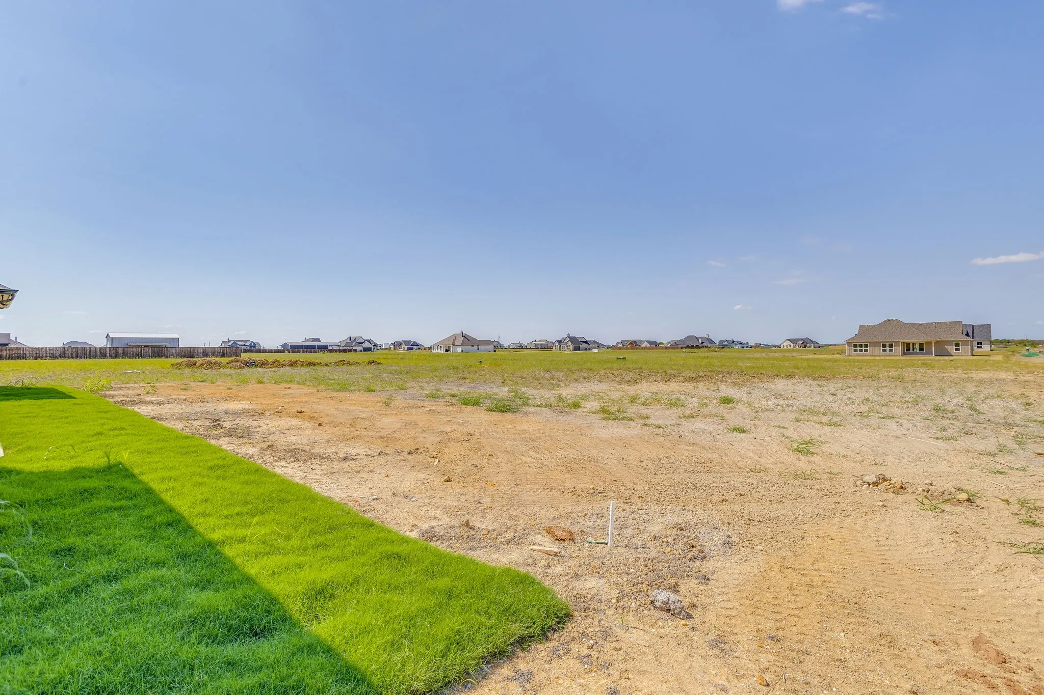 Expansive undeveloped lot with partial turf landscaping