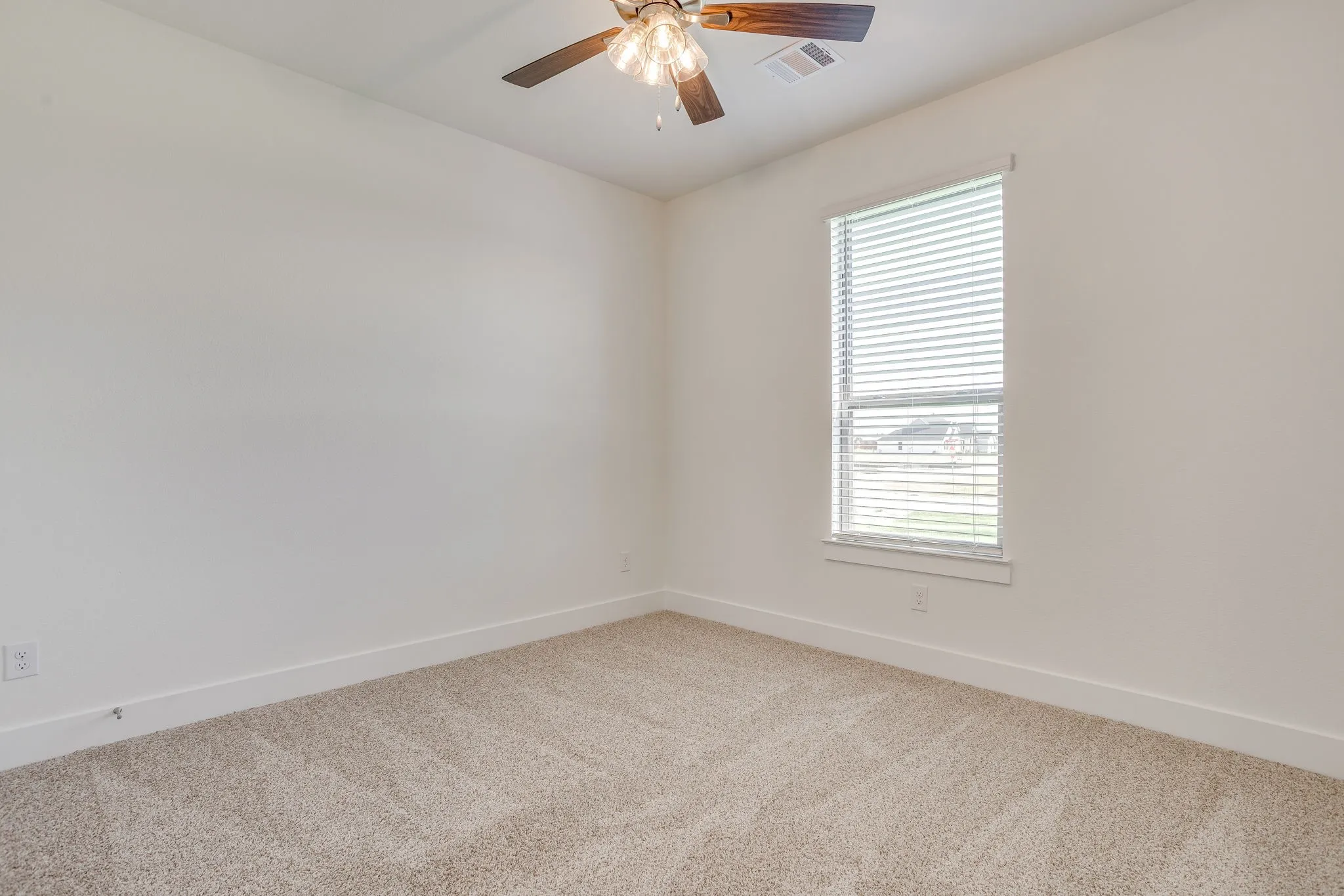 Neutral tone wall finishes, window with horizontal blinds, ceiling fan with light fixture, and carpeted flooring