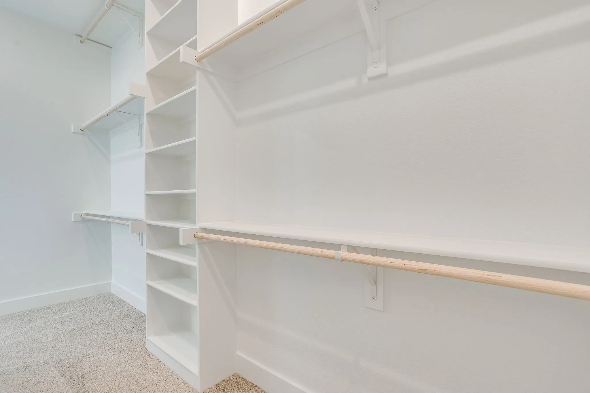 Built-in storage solutions with multiple shelving units and hanging rods