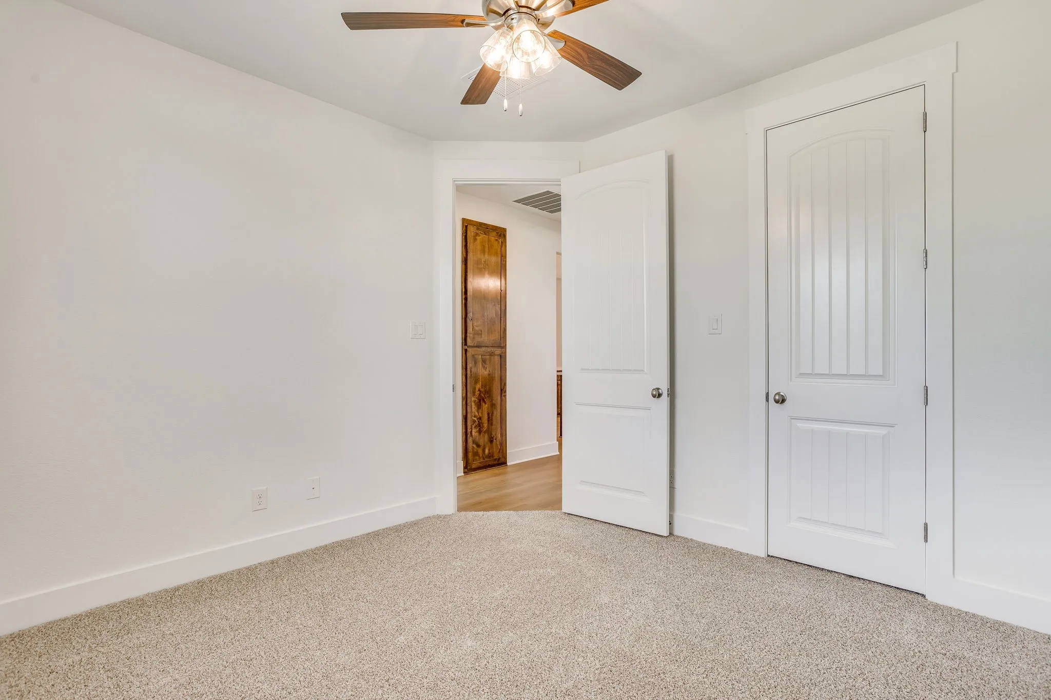 Carpet flooring, white walls, and a ceiling fan with light fixture