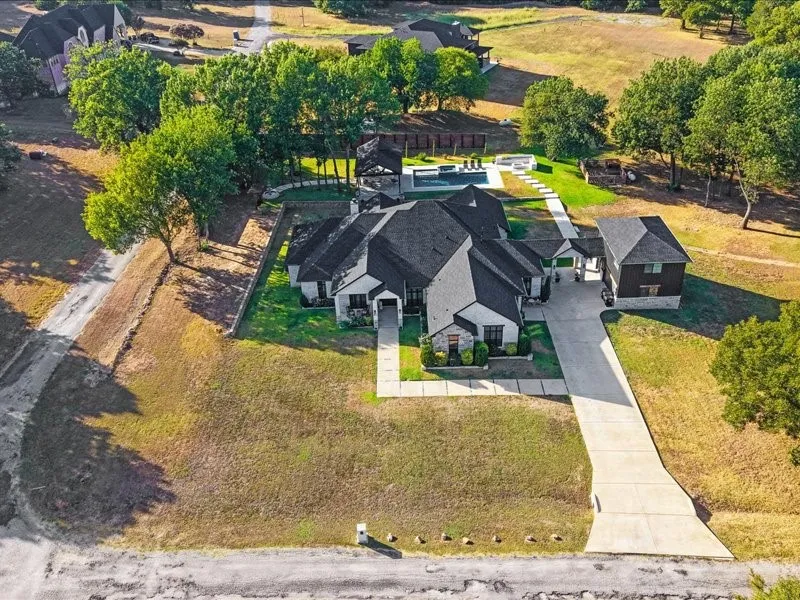 Expansive property featuring a concrete driveway, detached structure, and a large swimming pool