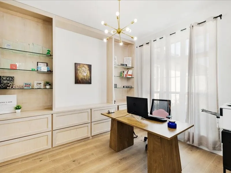 Built-in cabinetry with glass shelving, wood-finish flooring, and a contemporary light fixture