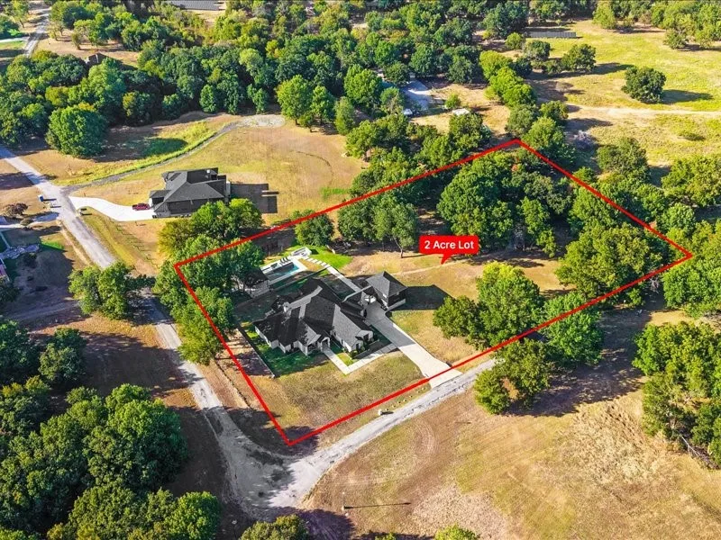 Spacious 2-acre lot featuring a contemporary residence, an elongated driveway, and a swimming pool