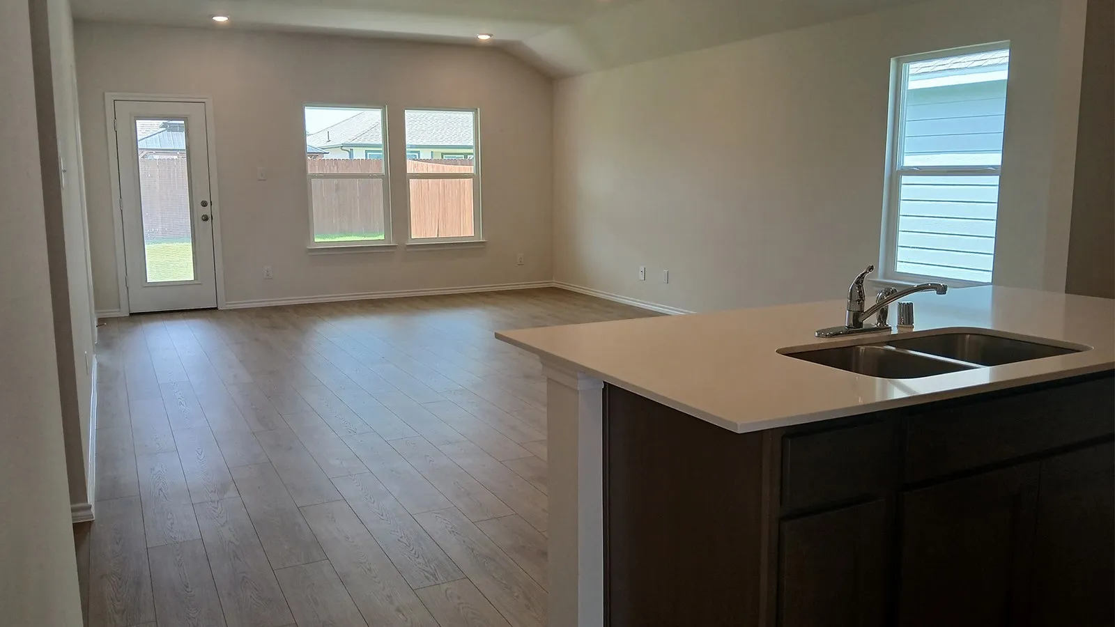 Open-concept living area featuring wood-finish flooring, recessed lighting, and ample natural light from multiple windows