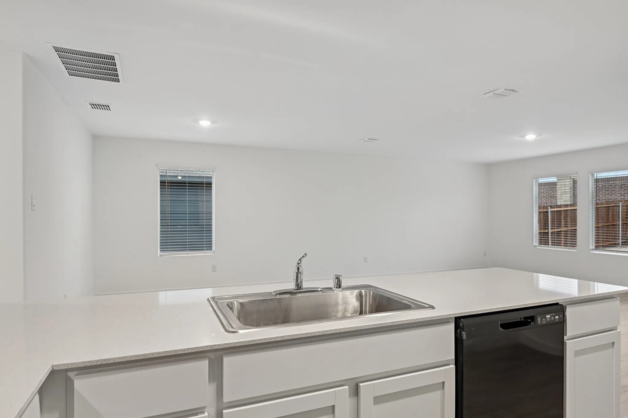 Kitchen with dishwasher, sink, and white cabinets