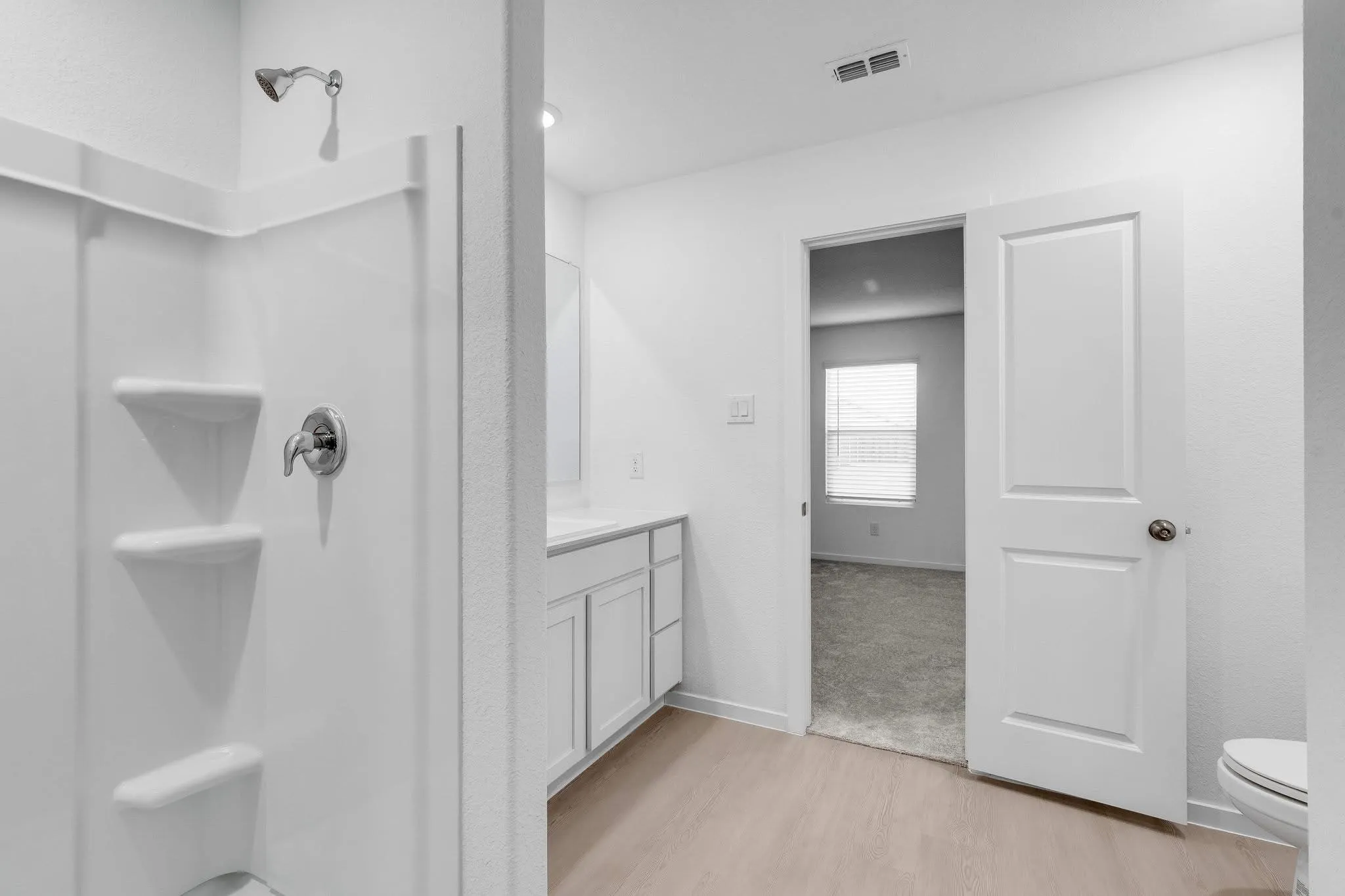 Full bathroom with toilet, wood finished floors, vanity, visible vents, and baseboards