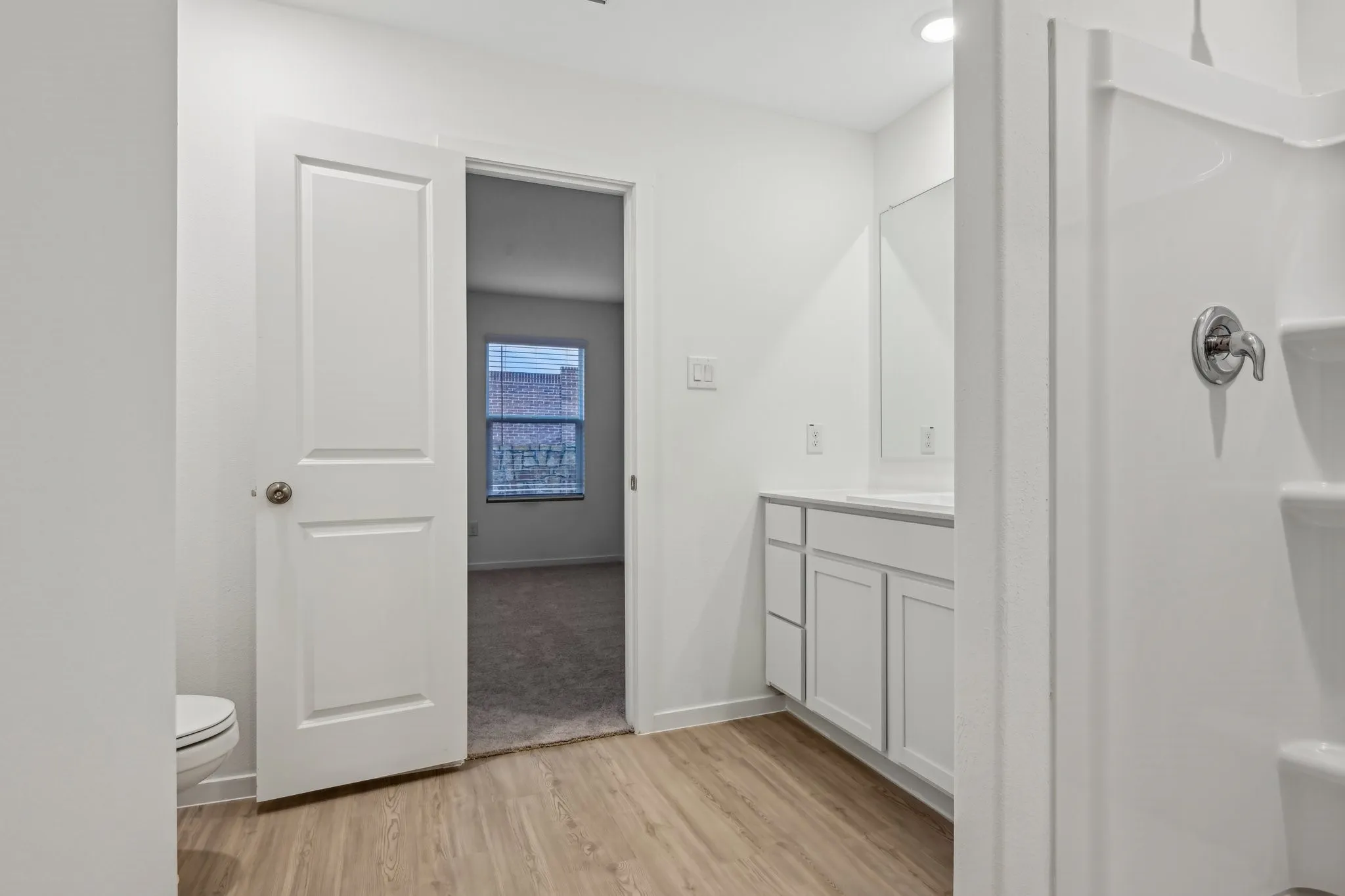 Bathroom featuring vanity, hardwood / wood-style flooring, and toilet