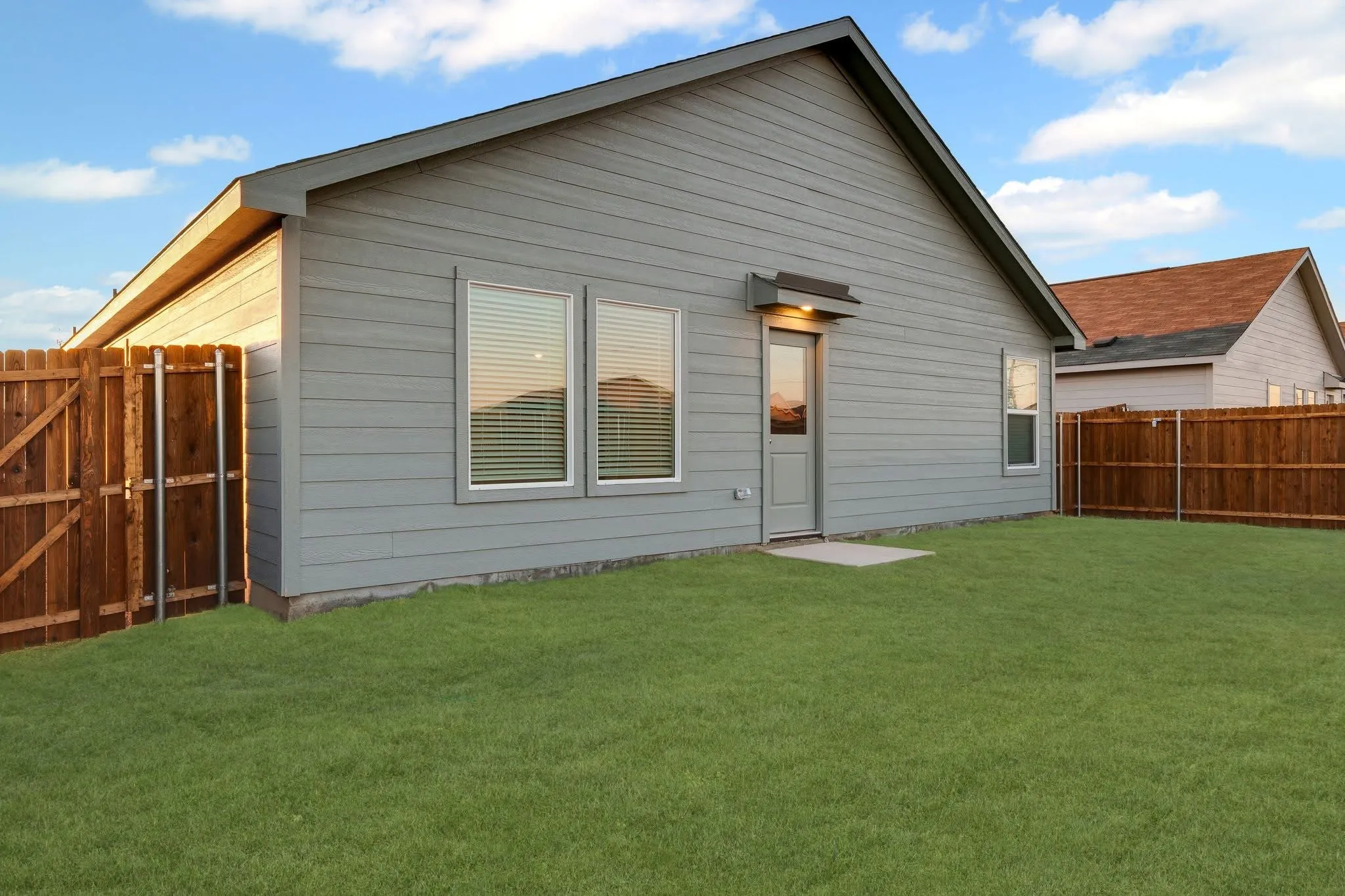 Back of house featuring fence and a yard