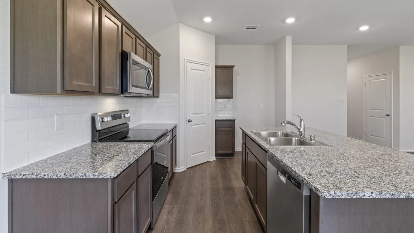 Kitchen featuring wood-finish flooring, granite countertops, white subway tile backsplash, and stainless steel appliances