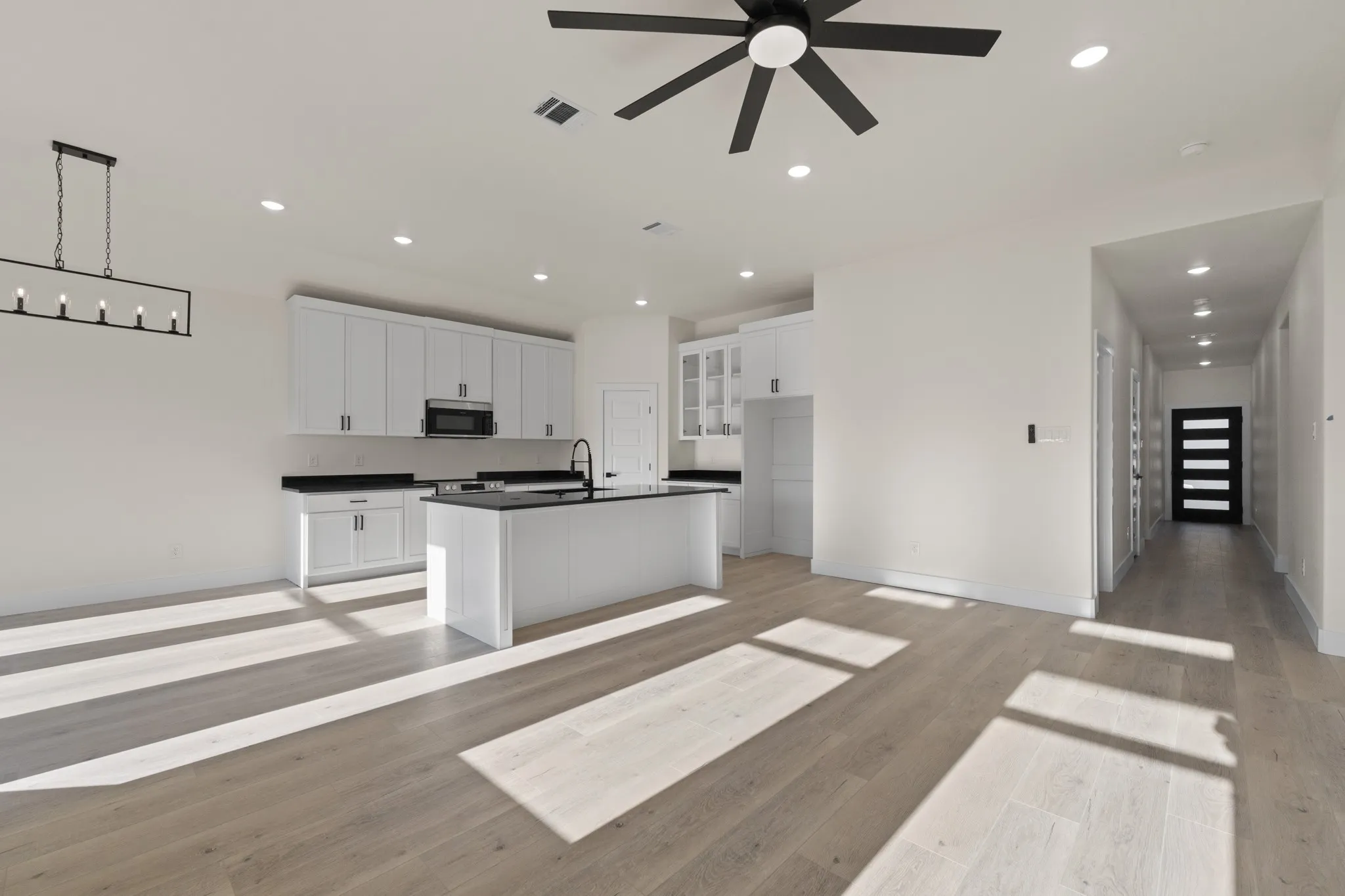 Open concept living space featuring wood-finish flooring, recessed lighting, and a modern ceiling fan