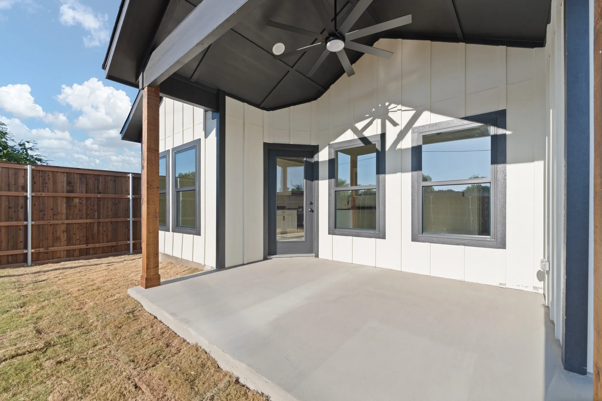 Spacious covered back patio featuring a modern ceiling fan, recessed lighting, and plenty of room for outdoor seating and entertaining. Private fenced-in backyard.