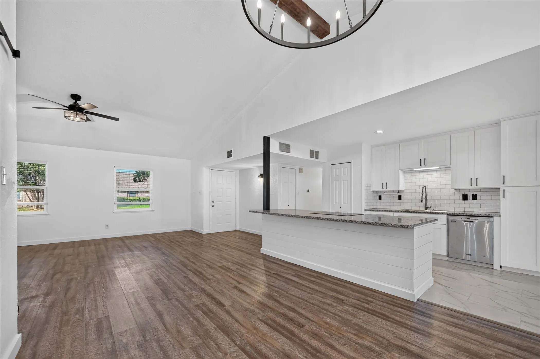 Vaulted ceiling featuring a decorative chandelier, recessed lighting, and a ceiling fan