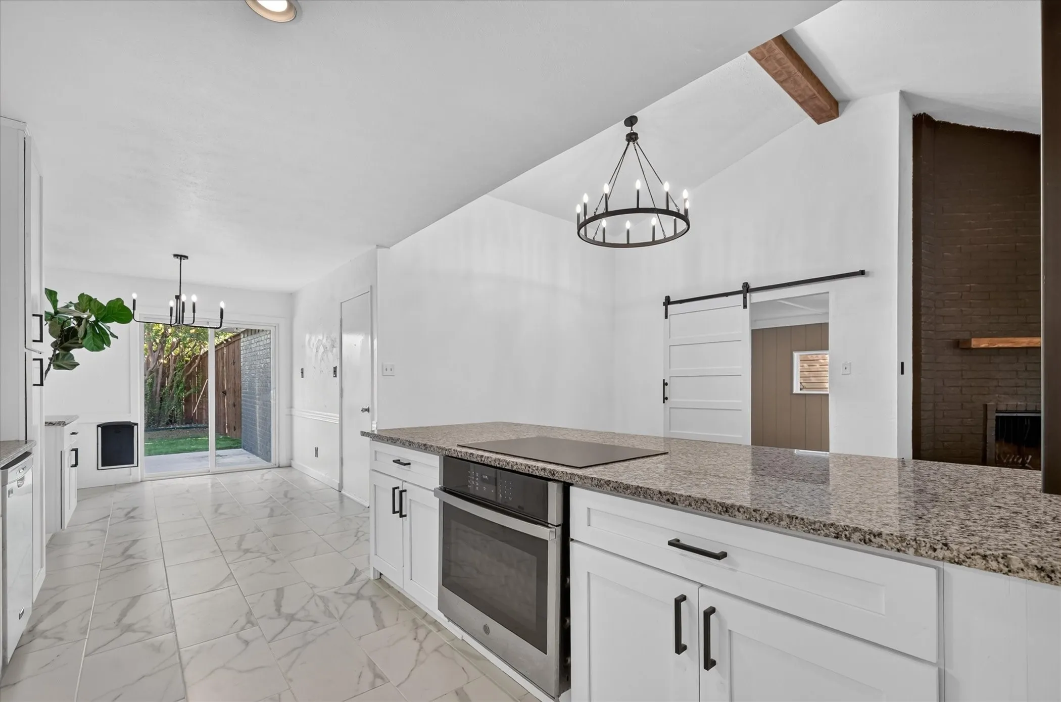 Kitchen island with granite countertops, integrated cooktop, and built-in oven