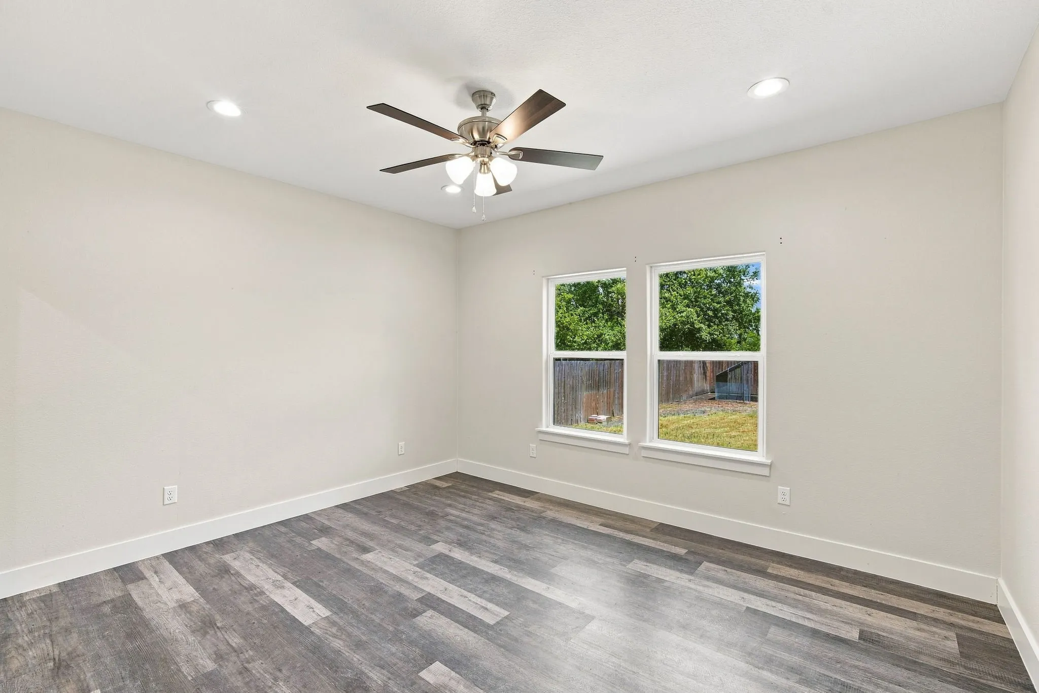 Wood-finish flooring, recessed lighting, and a ceiling fan with light fixture