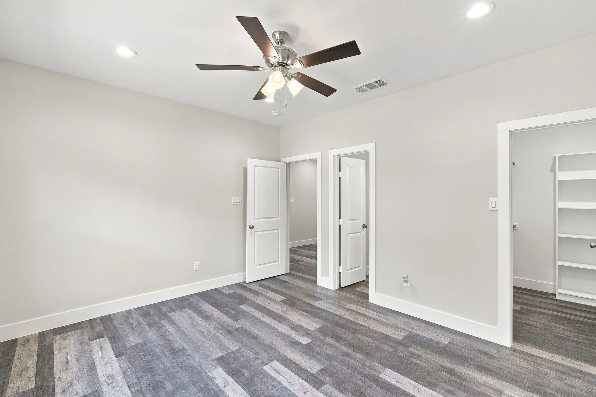 Wood-finish flooring, recessed lighting, ceiling fan with light kit, and built-in shelving