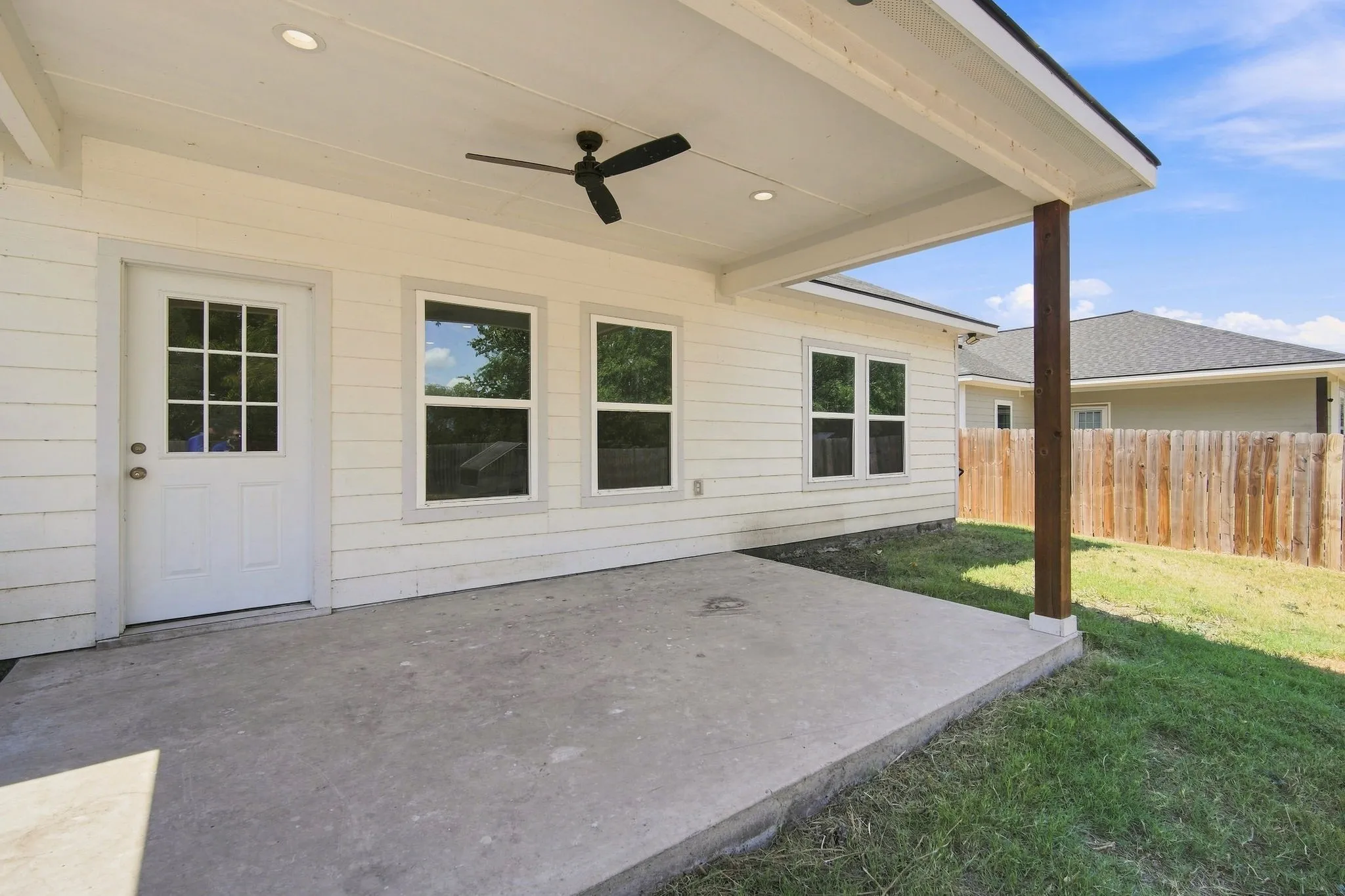 Covered concrete patio featuring a ceiling fan, recessed lighting, and a wood support column