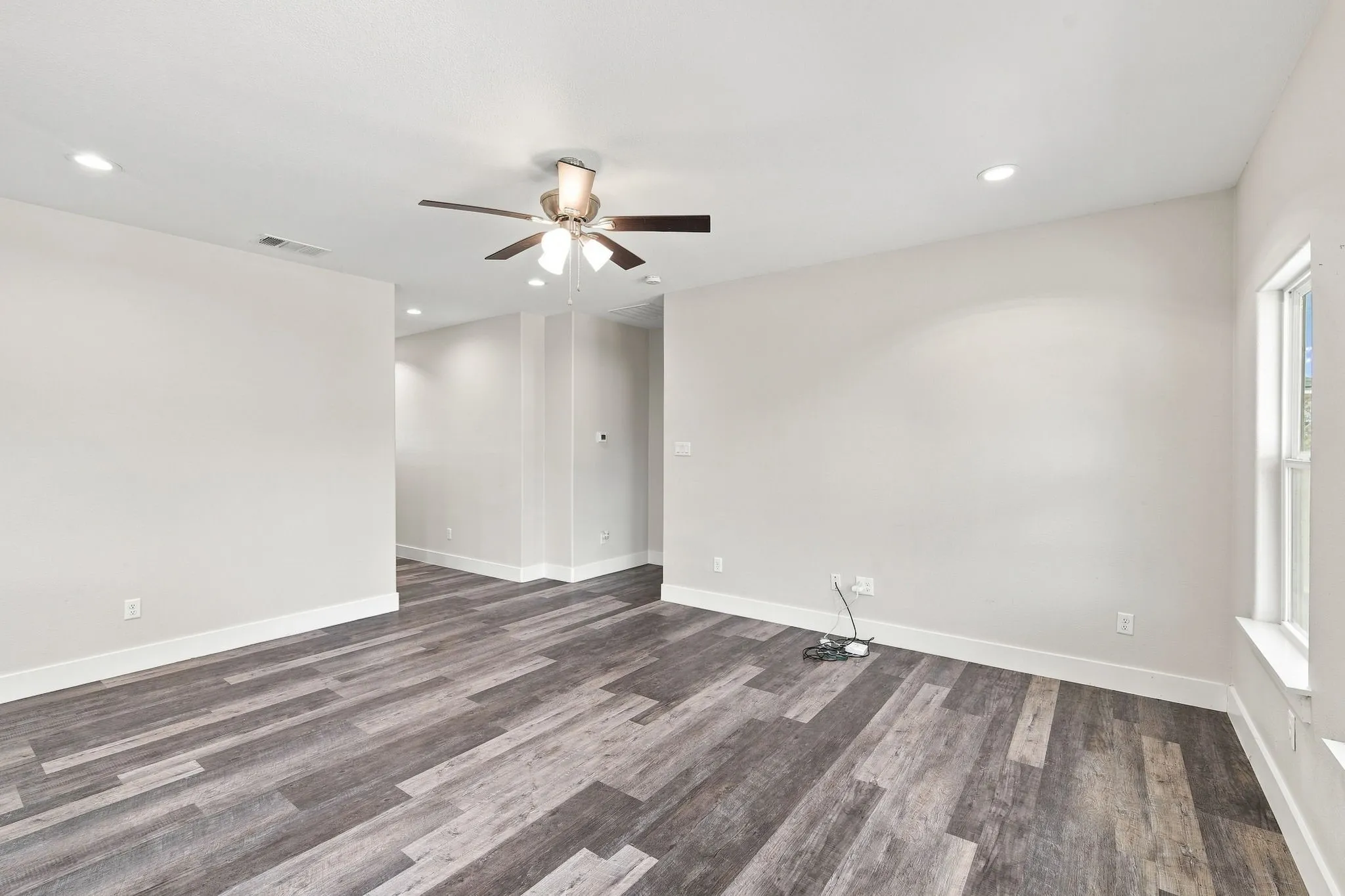 Spacious interior with wood-finish flooring, recessed lighting, and a ceiling fan