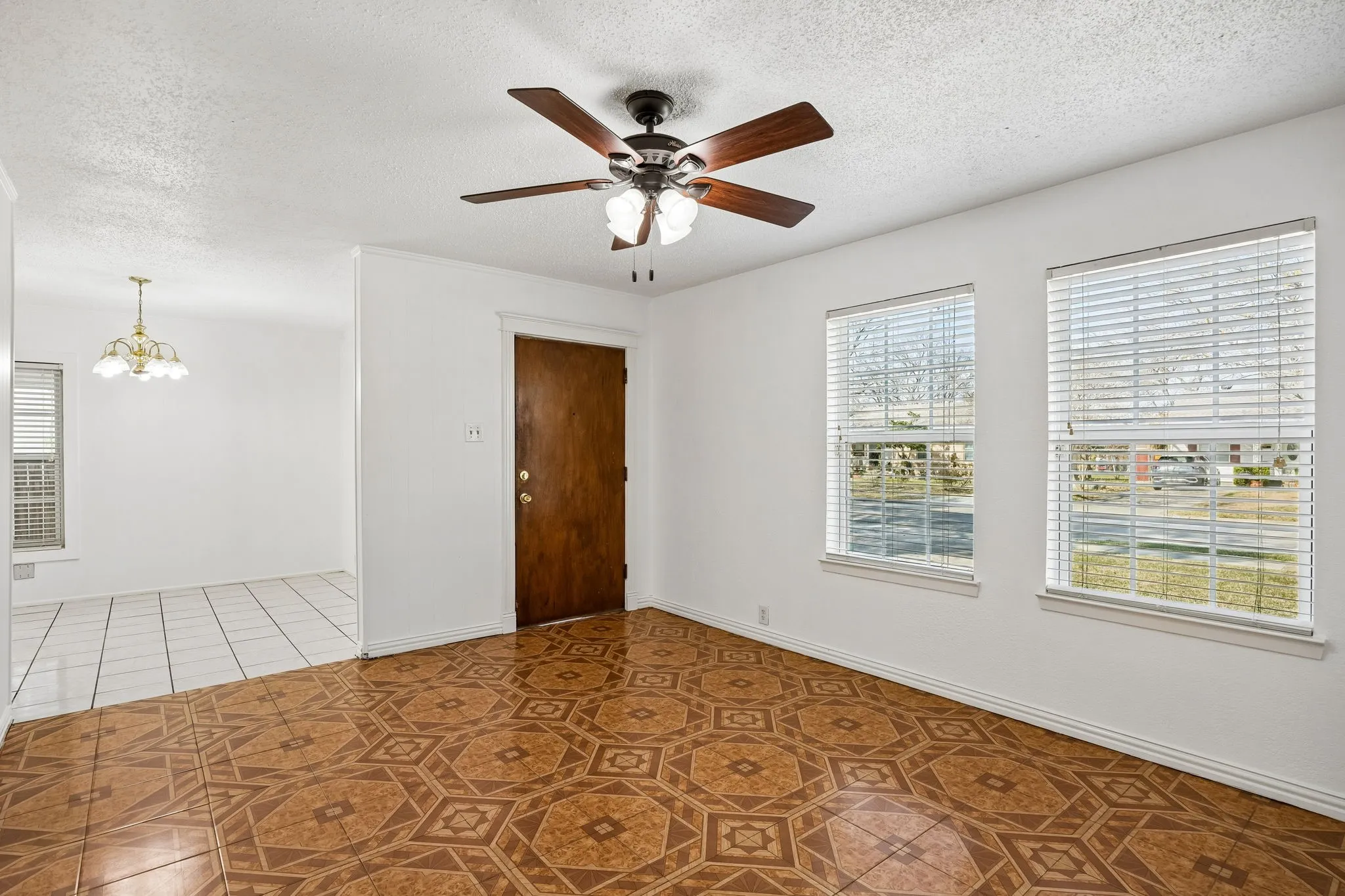 Open living room with views of front yard and open to the dining area.